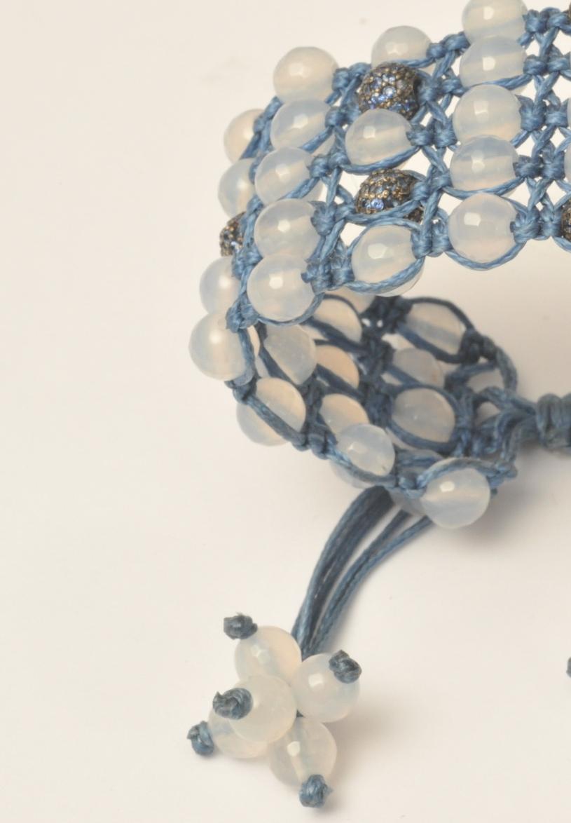 A very unusual cotton woven bracelet of 6 rows of faceted chalcedony beads with pave` set blue sapphire beads set in an oxidized sterling silver.  Adjustable.  Smallest setting is 6 inches.  