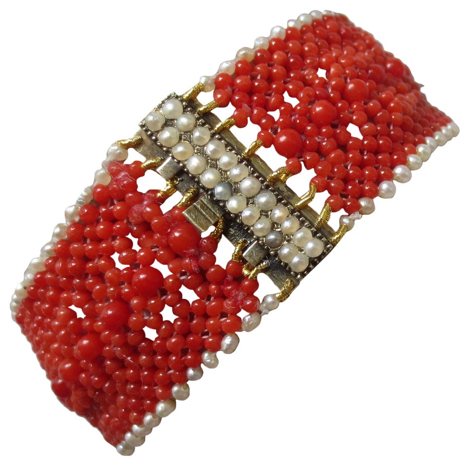 This woven coral and pearl bracelet with a pearl and 14k yellow gold clasp is become a classic and timeless piece. The bracelet is hand woven with 1 to 3 mm red coral beads, then accented with an out line of delicate white seed pearls, creating a