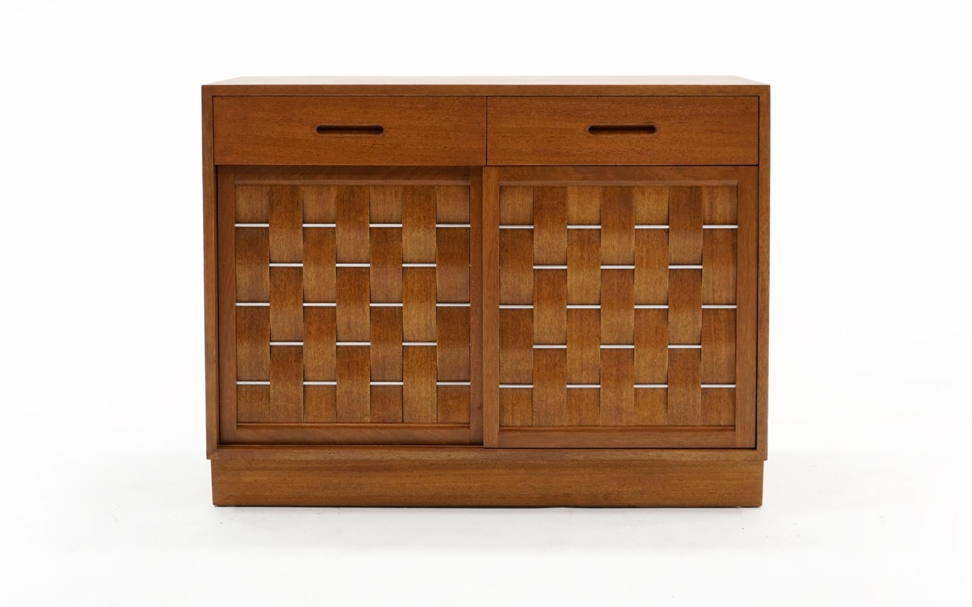 Mahogany storage cabinet with woven sliding doors and drawers designed by Edward Wormley for Dunbar. The two sliding doors have fronts woven with thin pieces of mahogany and nickel plated steel. Two drawers are above the sliding doors and another