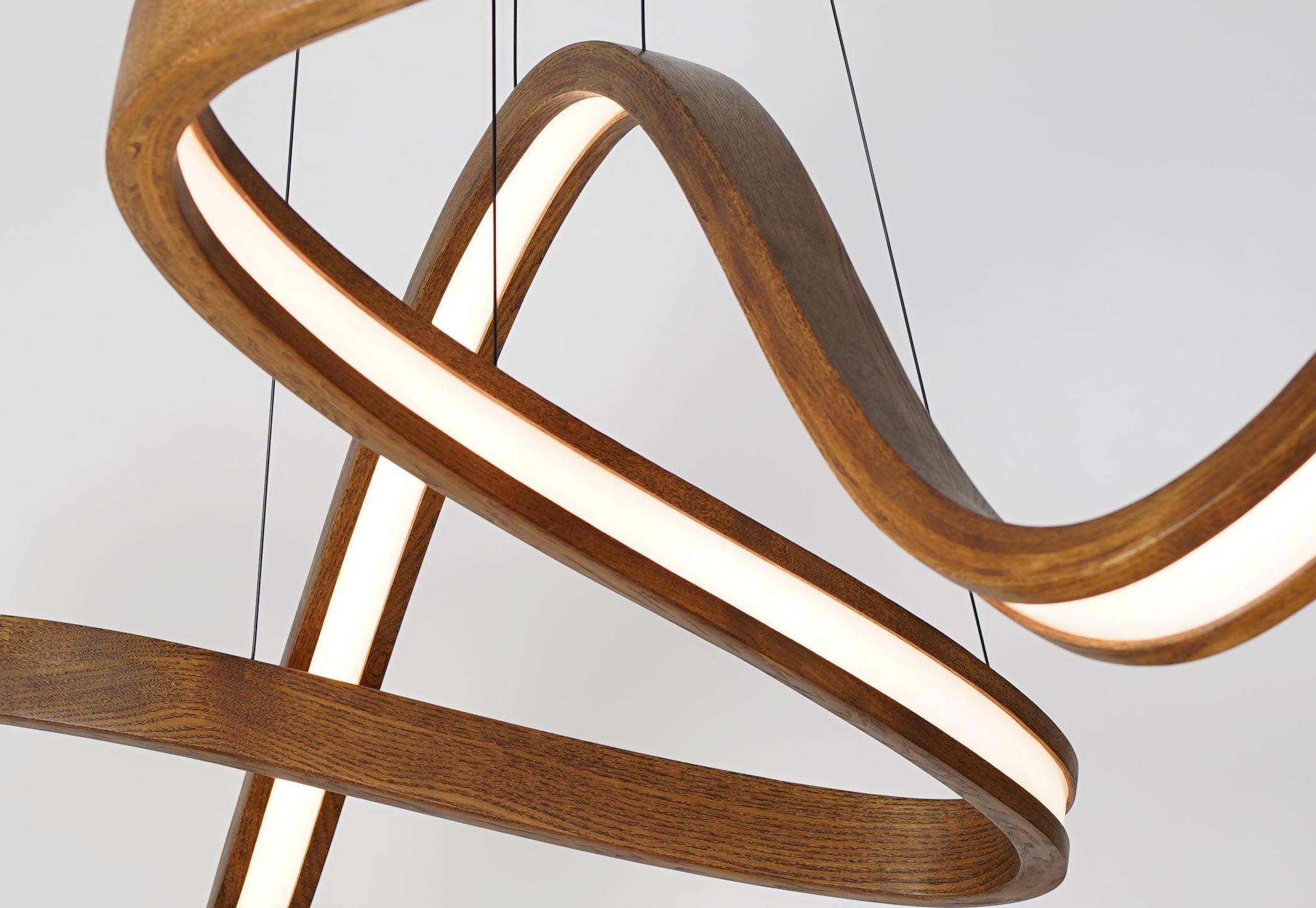 The woven is a independent modular freeform pendant formed from wood, woven diffuser, and high-output dimmable LED. The independent modular nature allows for a varying number of bent forms (two, three, four, etc.) to interwoven together but remain