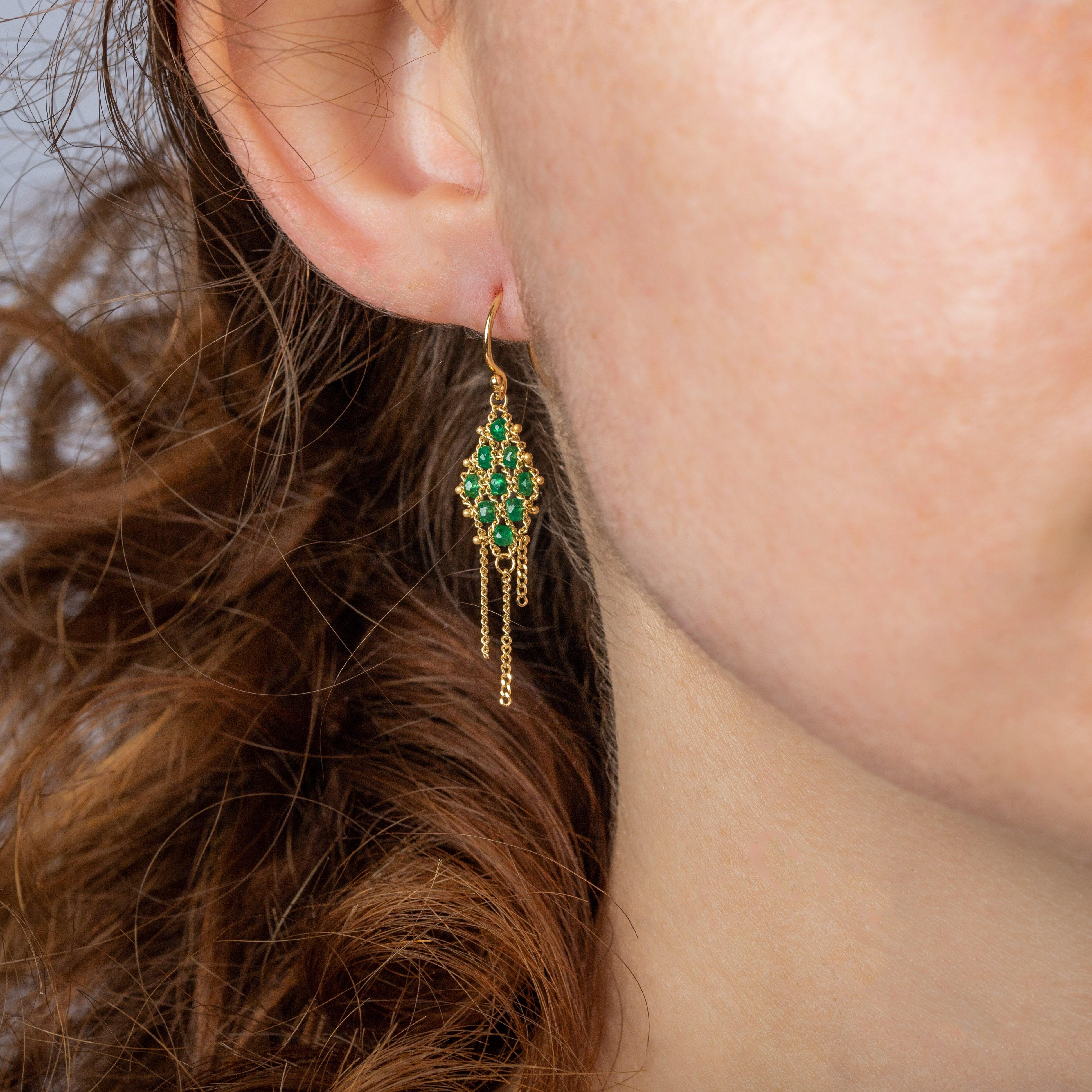 A delicate lattice of hand-woven 18K yellow gold chain suspends a verdant, kite-shaped arrangement of lush green Emeralds in this unforgettable pair of earrings. Further gold chains drip from the base of the kite, forming a tiny trio of sunshine