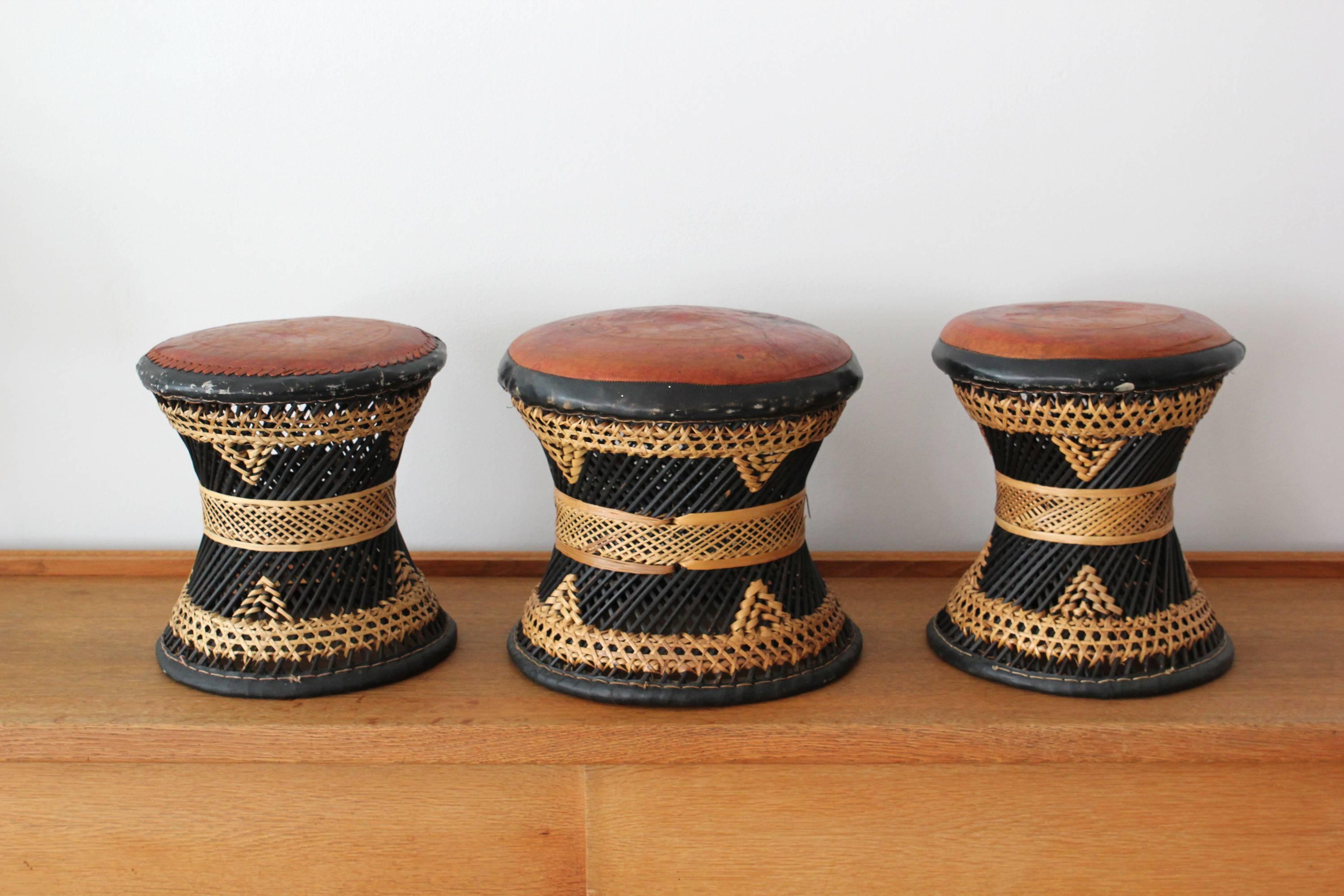 Ethnic woven rattan, wicker and leather stools.
Fantastic patina and design. 
Sold individually. 

Stools are slightly different in size:
Left to right from main image: 11.5