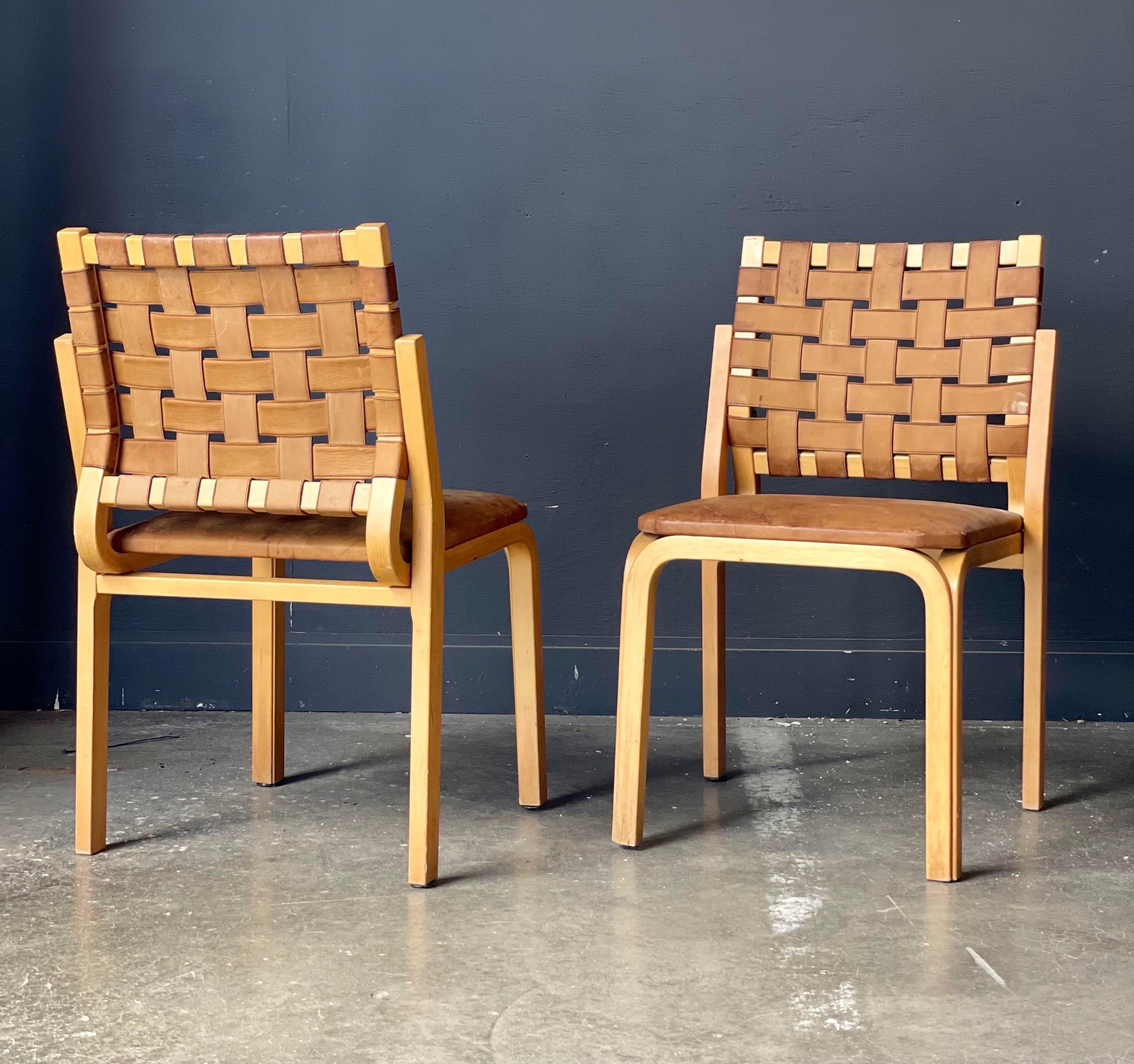 A fun pair of mid century bentwood chairs. Simple maple frames have square leather seats and woven leather seat backs.