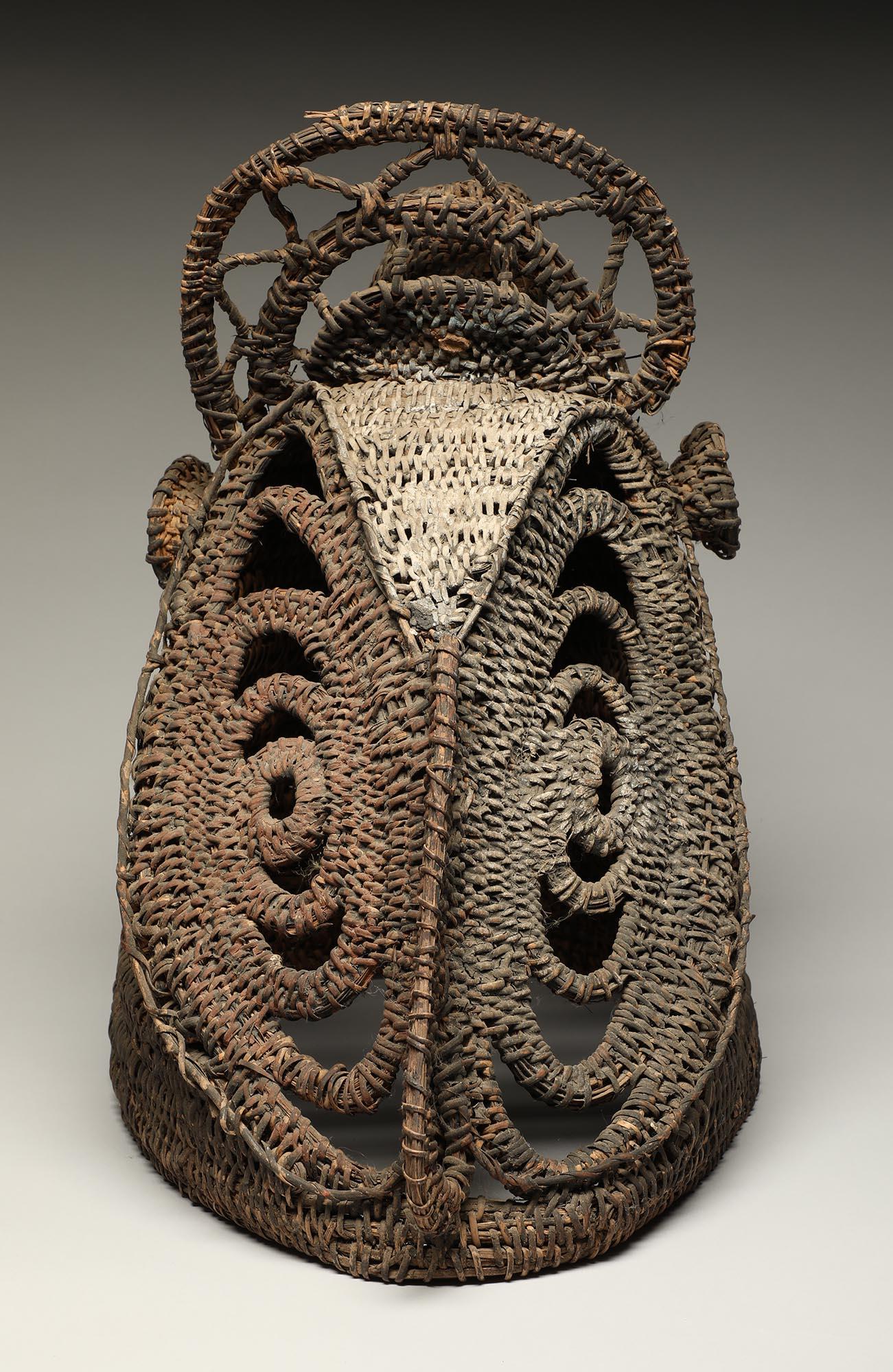 Masque casque d'igname en vannerie peinte de Papouasie-Nouvelle-Guinée. Forme creuse tissée avec des traces de pigments rouges et blancs. Mesures : 14 1/2 pouces de haut, milieu du 20ème siècle.