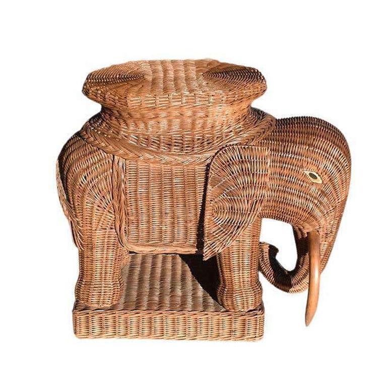 A fabulous brown wicker and rattan elephant side table. This beauty is a design lover's dream. The piece is woven from a mix of wicker and rattan and features a smooth top that would be great for resting drinks. The elephant has wooden eyes with