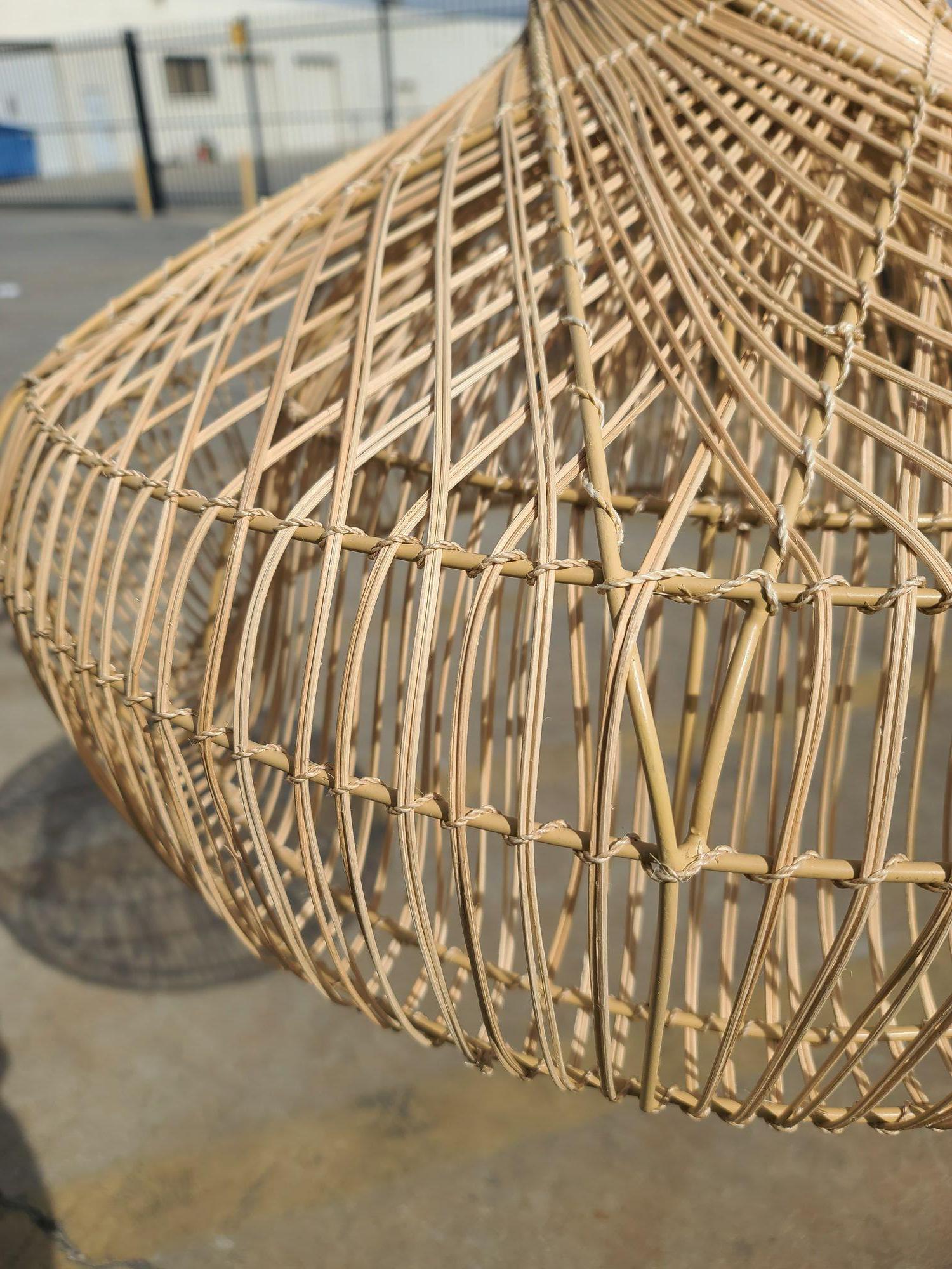 Original near-mint 1990s woven rattan hanging ceiling lamp pendant reminiscent of the style made famous by Franco Albini. The pendant features woven stick rattan pendant light hung from a black cloth-wrapped cord connected to a black ceiling plate.