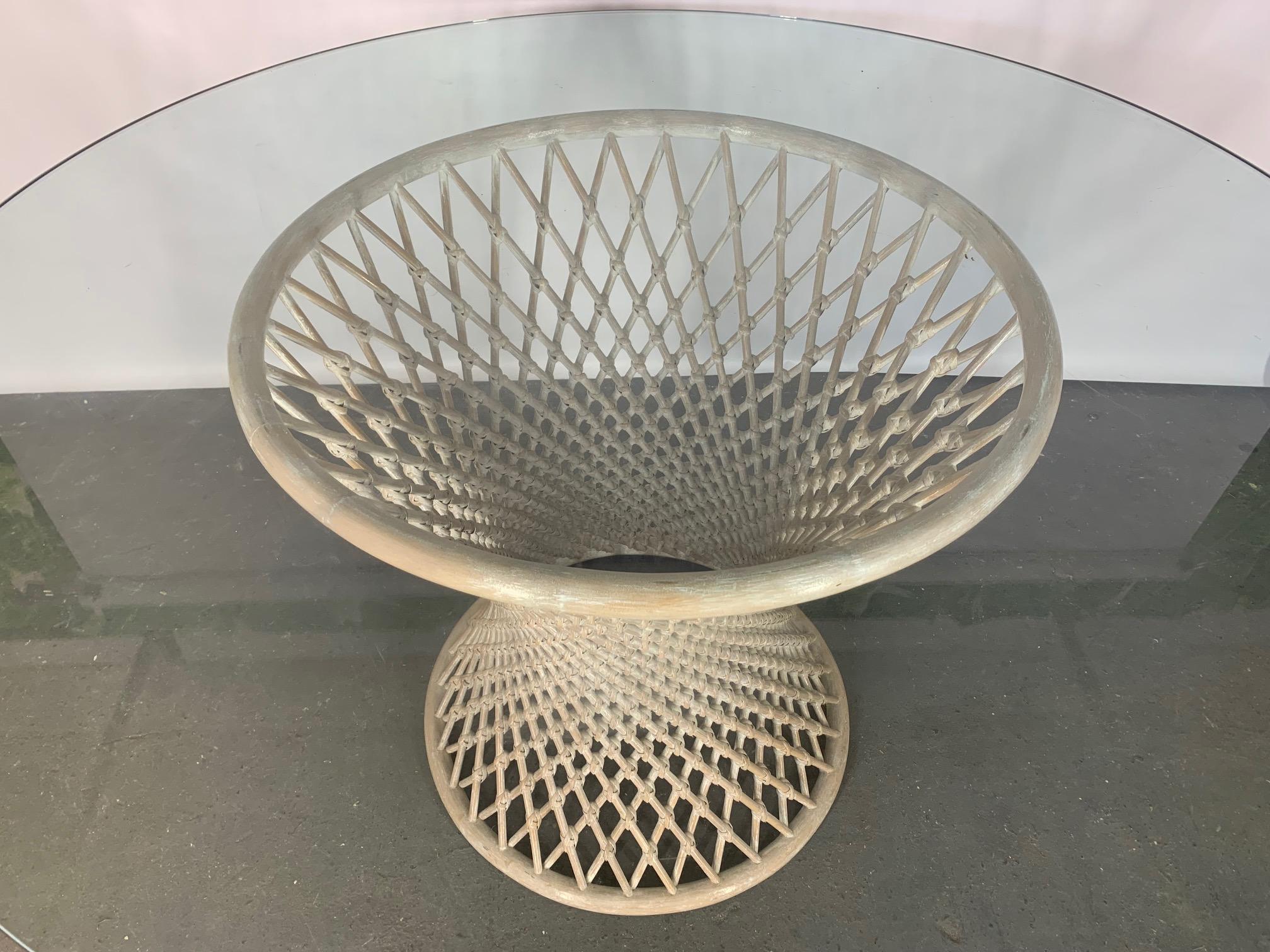 Woven rattan pedestal table features sculptural hourglass shape and round glass top. Very good condition with only minor imperfections consistent with age.