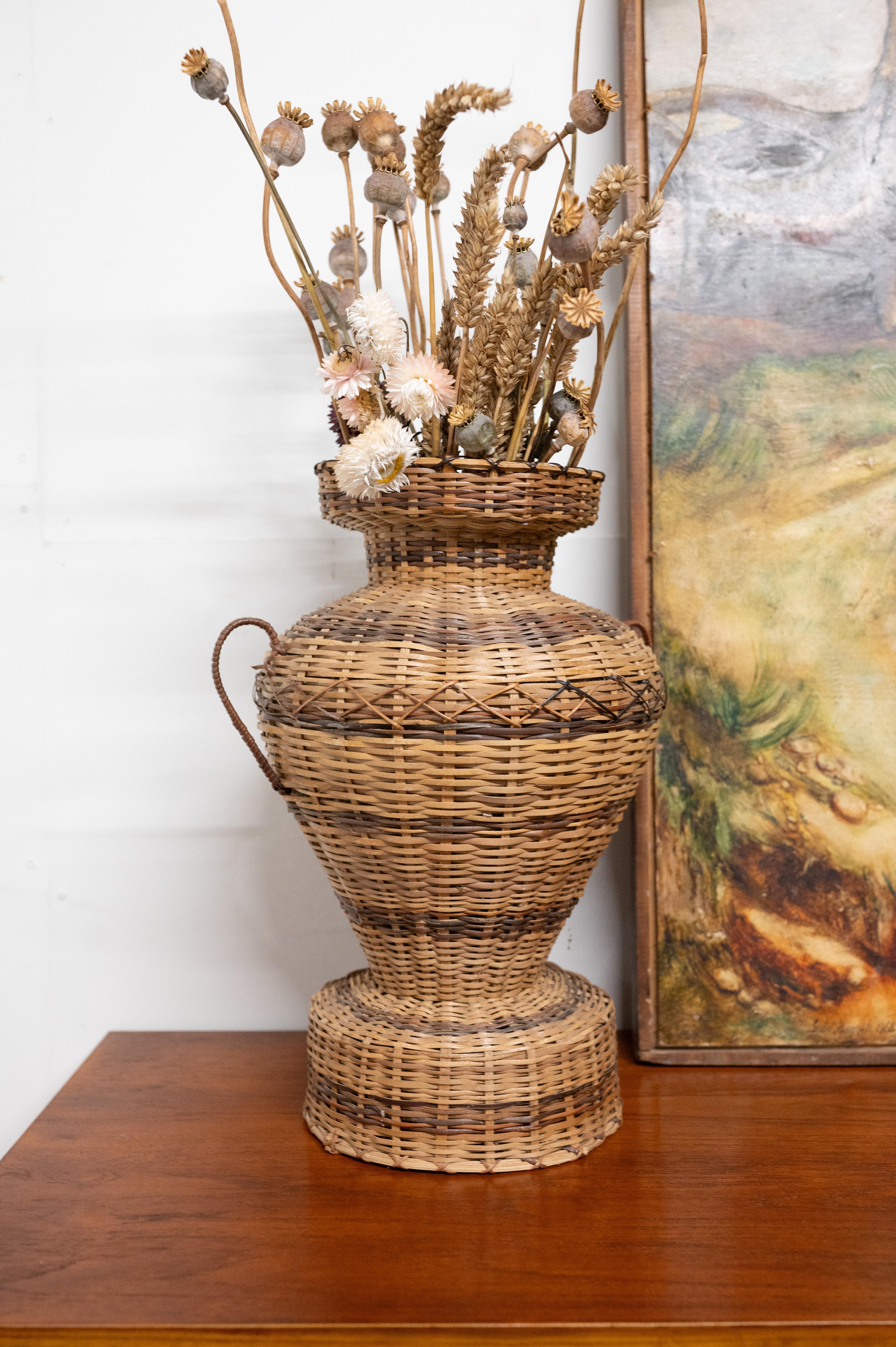 Une pièce charmante qui insuffle sans effort une beauté naturelle et une élégance rustique à votre espace. Fabriqué avec une attention méticuleuse aux détails, ce vase met en valeur l'art de l'osier tressé en rotin. Les motifs et les textures