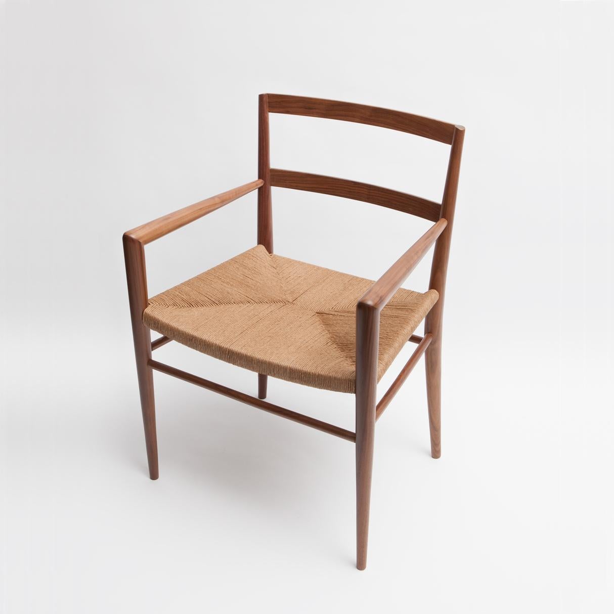 Conçu à l'origine par Mel Smilow en 1956 et officiellement réintroduit par sa fille Judy Smilow en 2013, le fauteuil de salle à manger en jonc tressé est classiquement du milieu du siècle. L'assise tissée à la main et le cadre en bois artisanal de