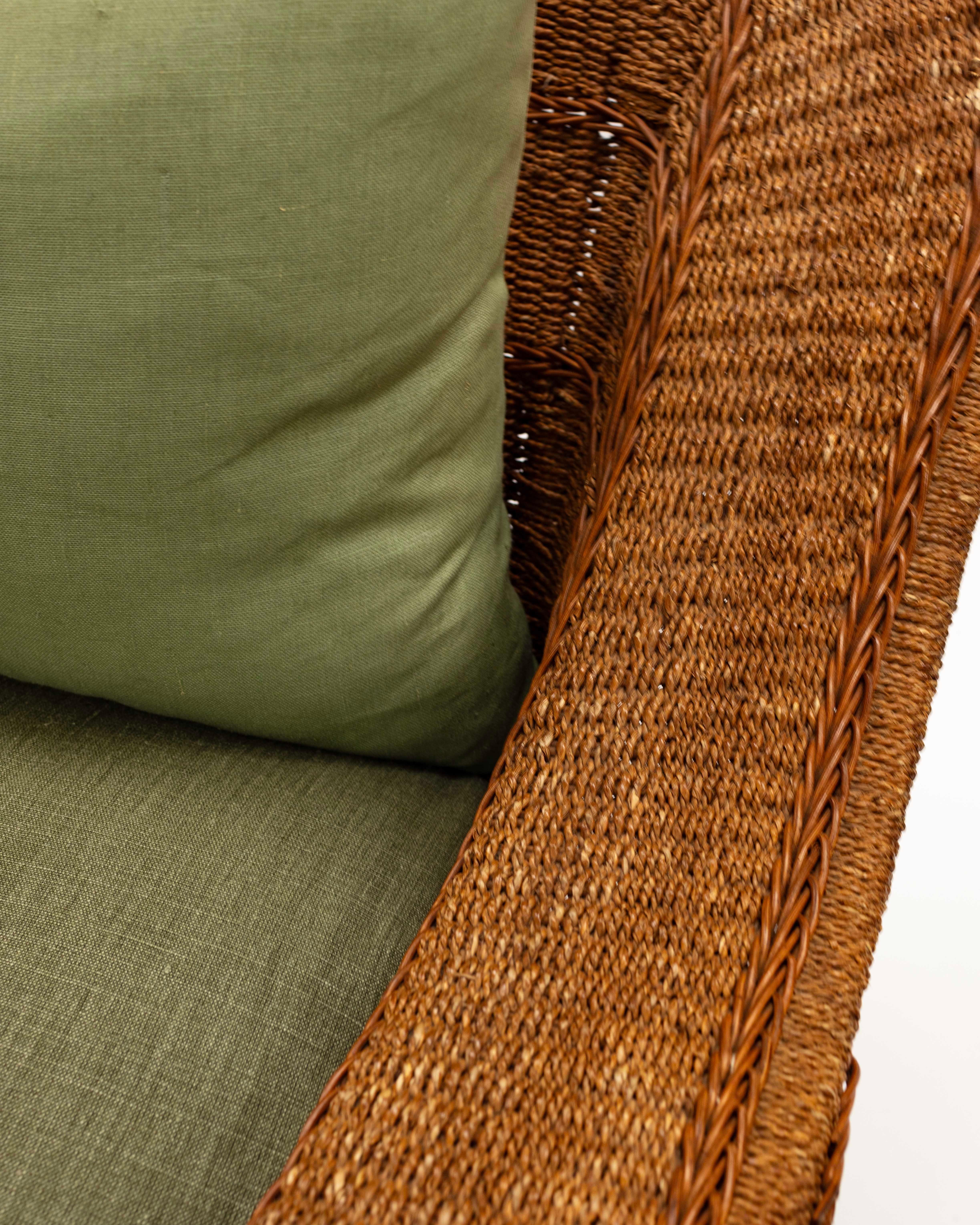 Woven Seagrass large chair with sloped back, tightly woven rush weave with braiding detail.  Heathered sage green canvas linen on seat and back cushion with very unique retractable leg rest.  Sturdy construction and high end upholstery.