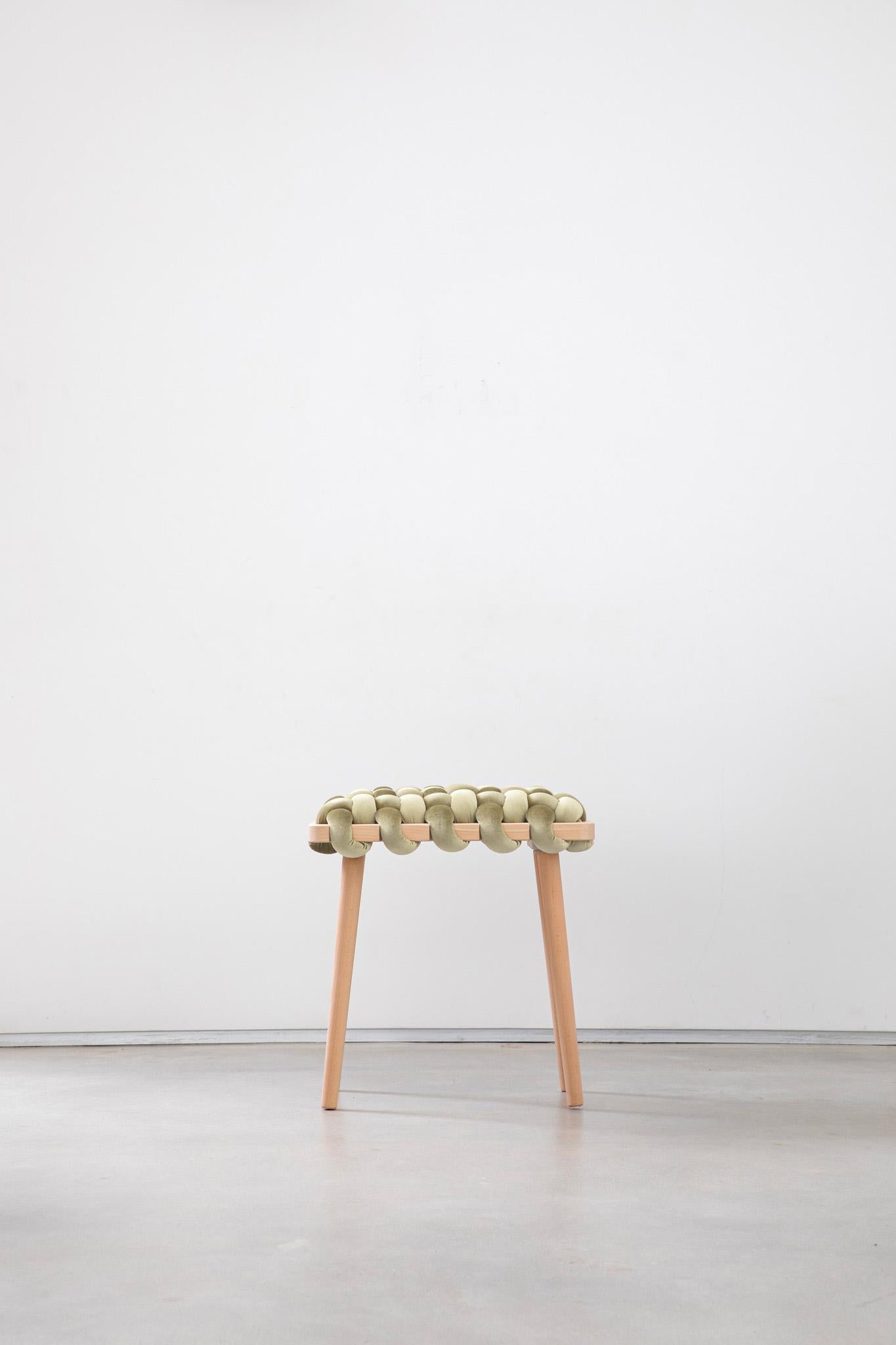Expertly crafted with a blend of fine velvet fabric and natural Beechwood, the hand-woven stool enhances any entryway or living space with its elegant and playful design. This lasting piece combines beauty and functionality, creating a stunning