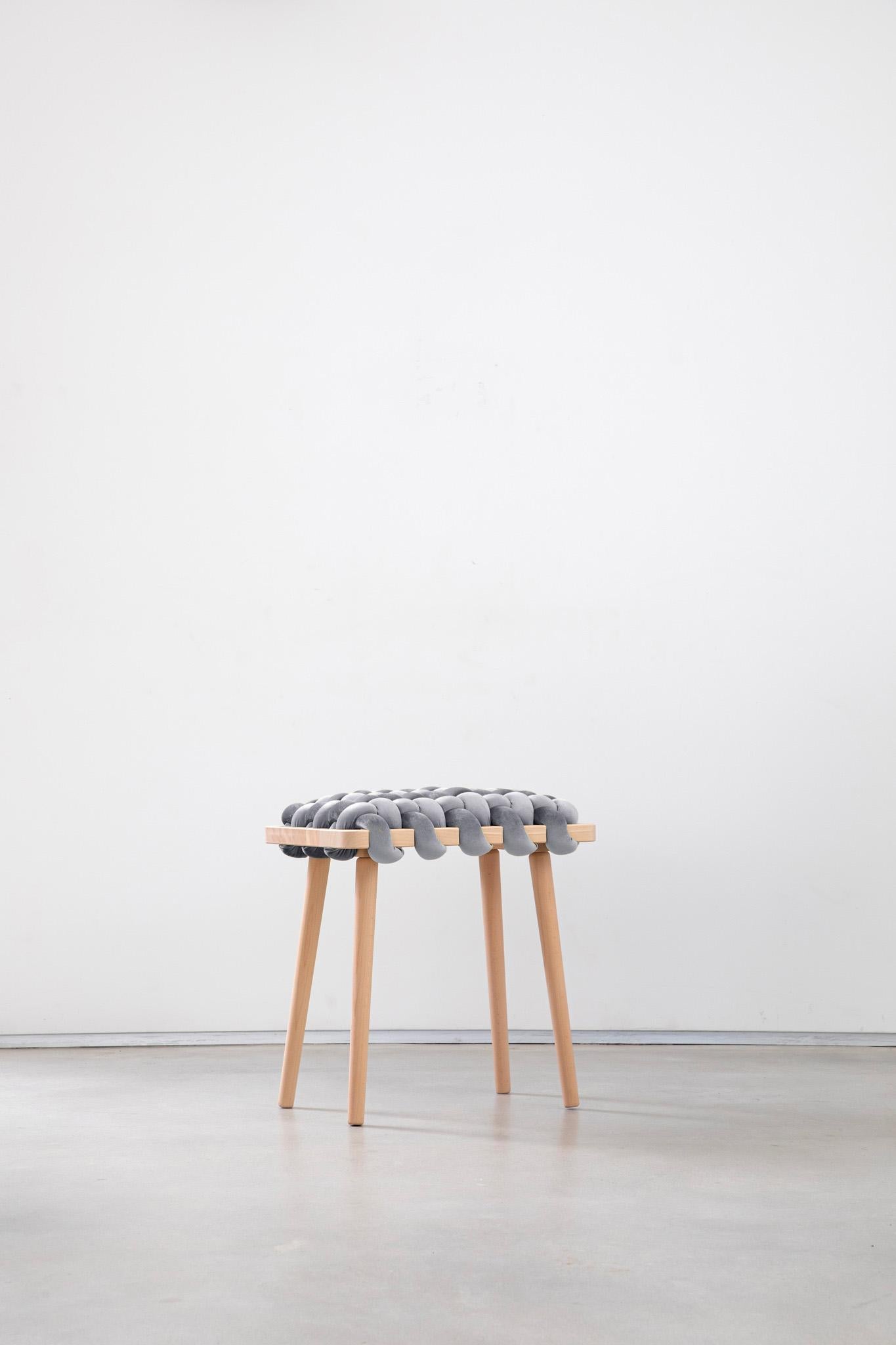 Expertly crafted with a blend of fine velvet fabric and natural Beechwood, the hand-woven stool enhances any entryway or living space with its elegant and playful design. This lasting piece combines beauty and functionality, creating a stunning