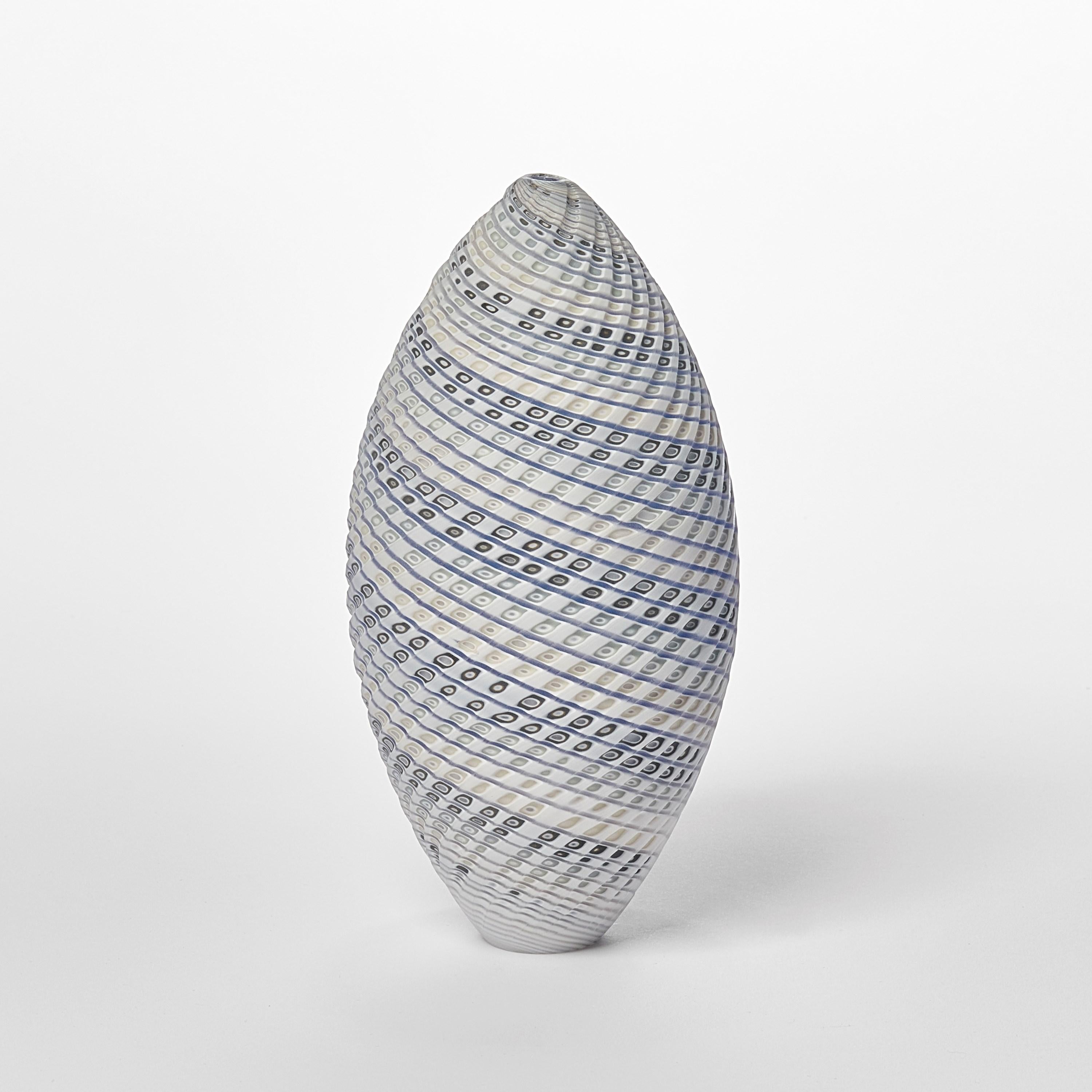 'Woven Three Tone Blue Ovoid (sm)' is a unique handblown, sculpted and cut glass sculpture by the British artist, Layne Rowe.

Rowe’s inspiration is drawn from the dramatic Devon coastline which informs his love for detail, a constant theme for his