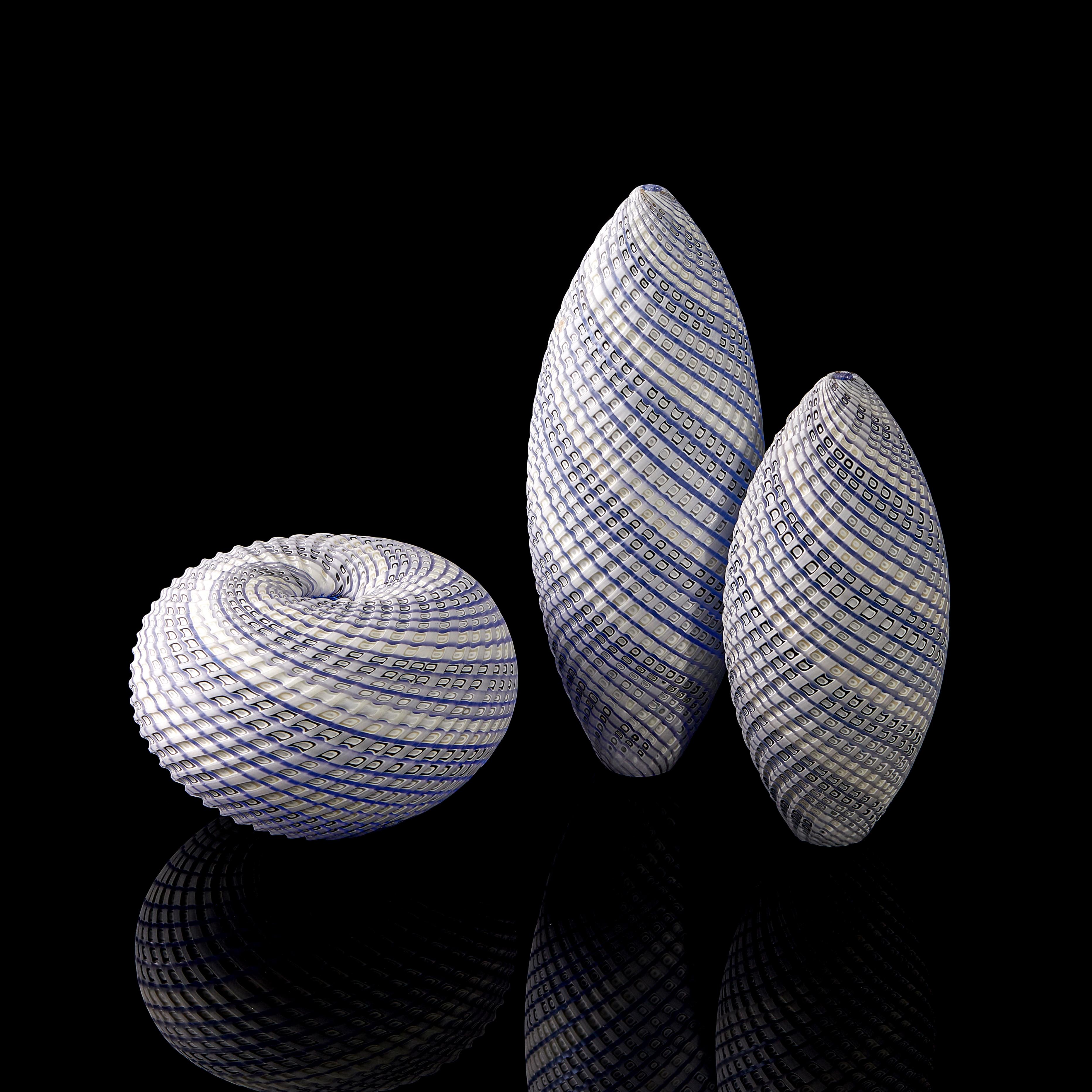Woven three tone blue trio is a unique soft blue, grey & white hand blown glass installation by the British artist Layne Rowe. Each artwork within the trio has been hand blown using pre-made glass canes, formed from layers of colour by the artist,