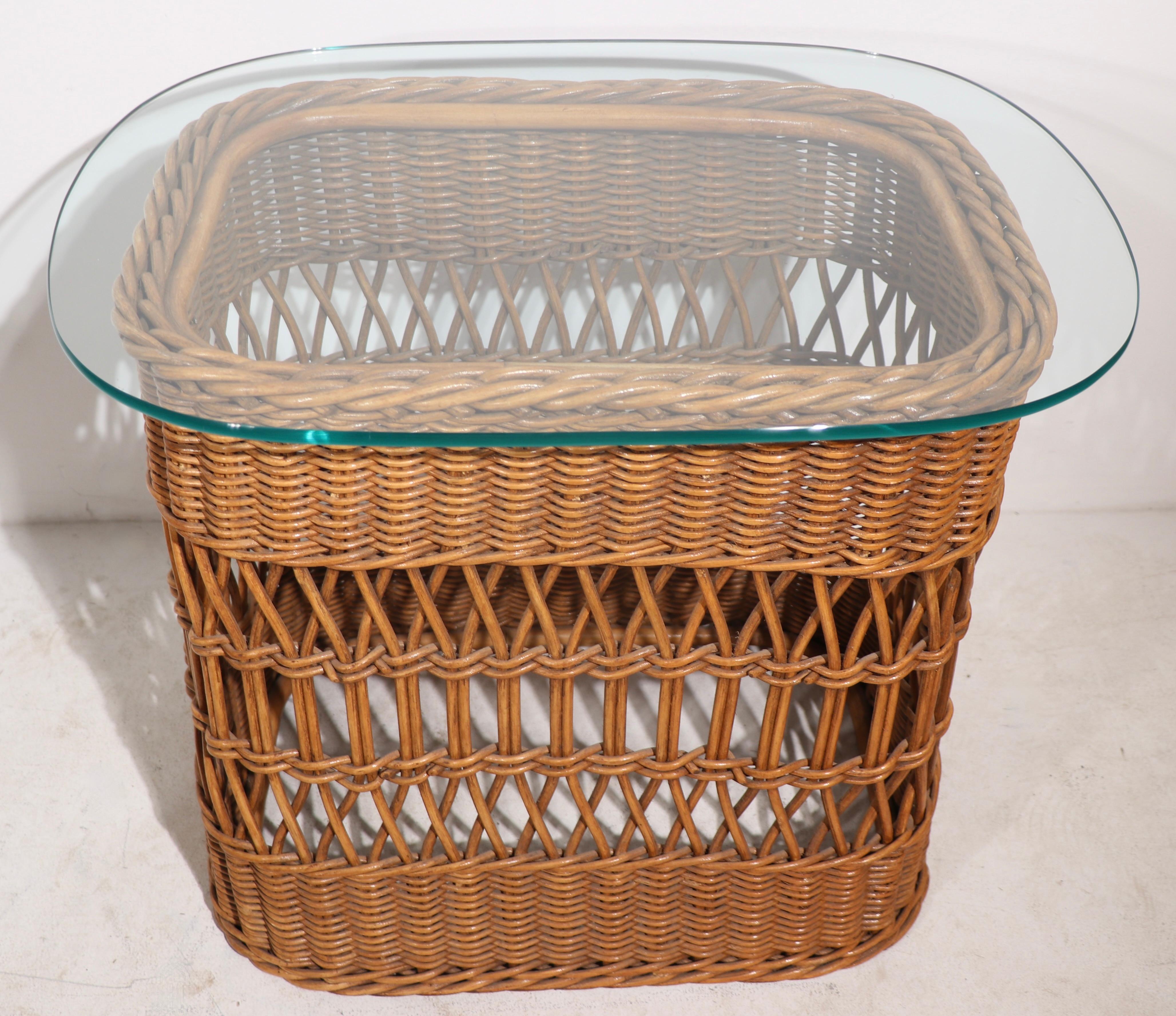 Chic pair of woven wicker end, or side tables having gusty rectangular bases, with original plate glass tops. The tables are excellent original condition showing only light cosmetic wear normal and consistent with age.