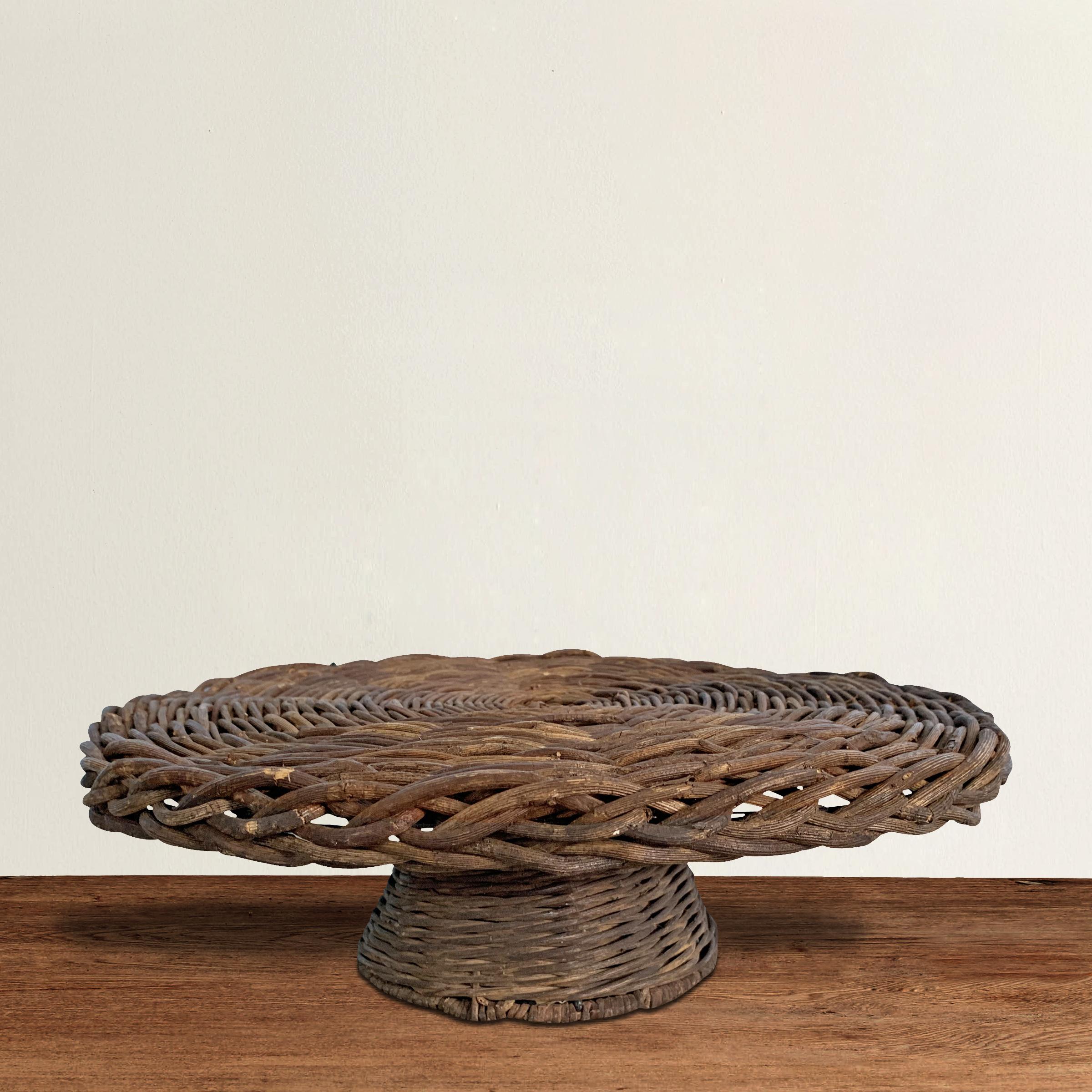 A charming 21st century American woven wicker cake stand waiting for your next confectionary treat.