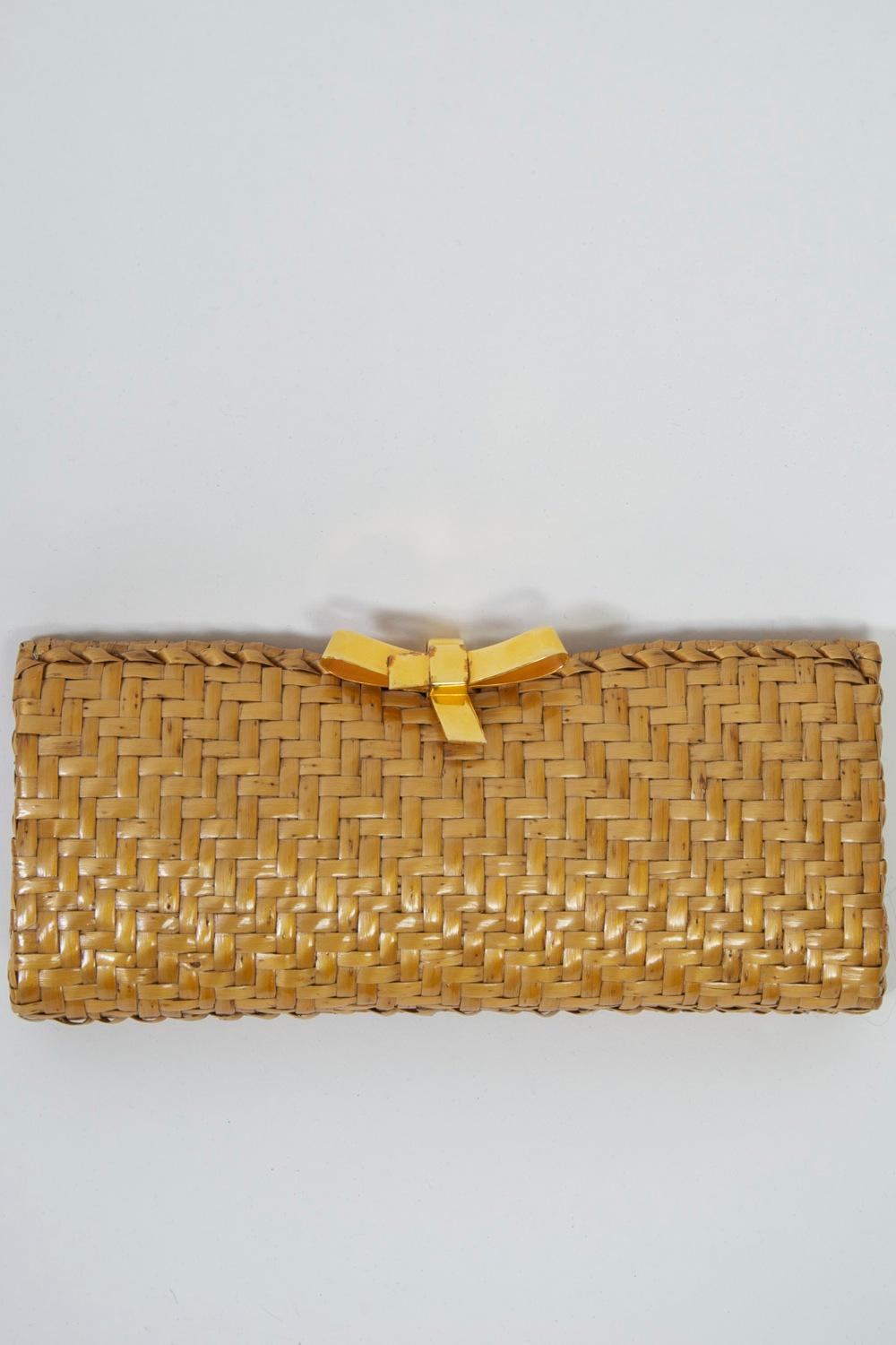 c.1980s clutch in natural woven wicker. Minimalist design of rectangular shape featuring bow-shaped clasp in gold tone metal. Synthetic interior with side pocket. Retailed by Saks 5th Avenue. 