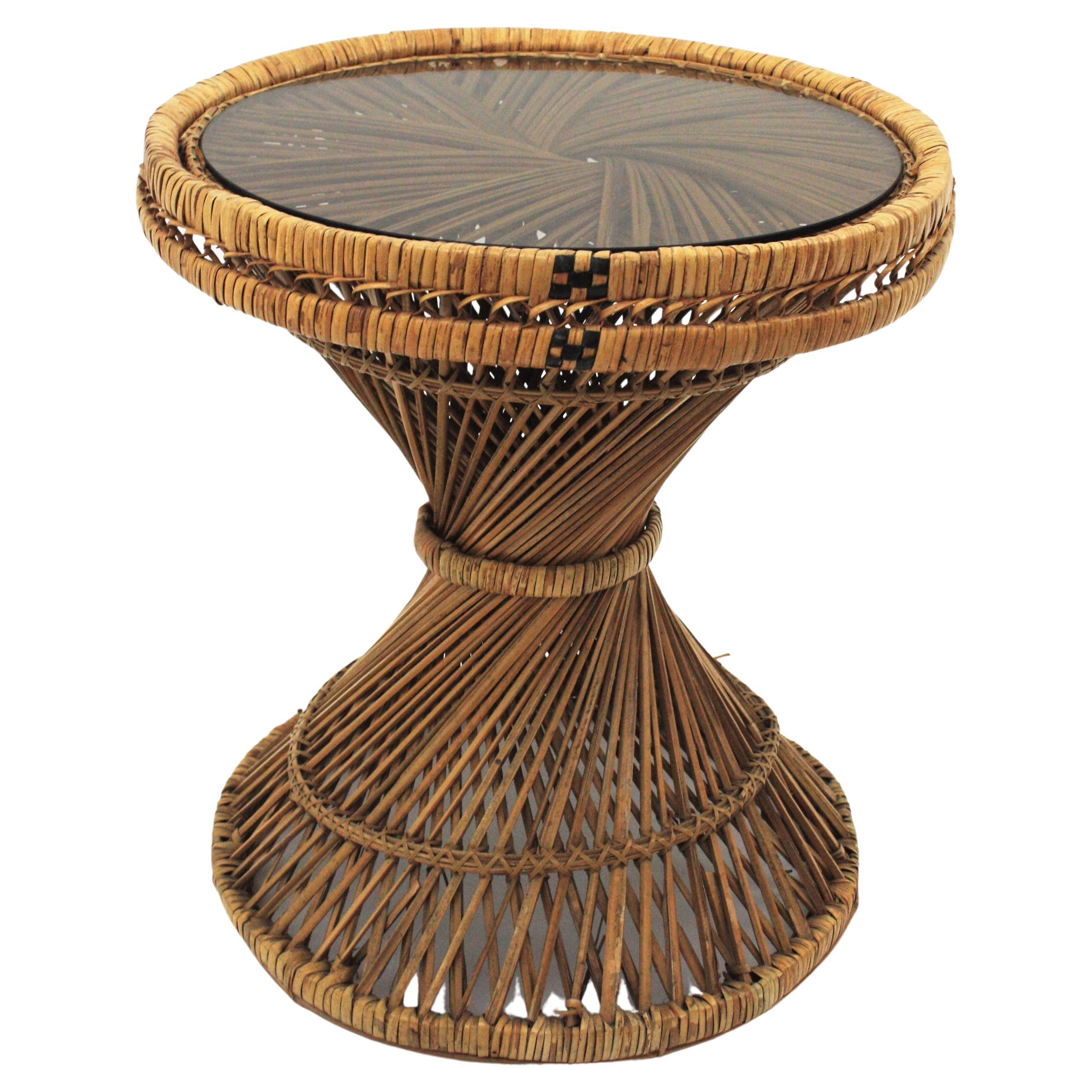 Round coffee table handcrafted in wicker and rattan in the manner of the Emmanuelle chair, Spain, 1960s.
This lovely round low table features an intricate of rattan and wicker canes with twisting at the central part.
Its design with a round top