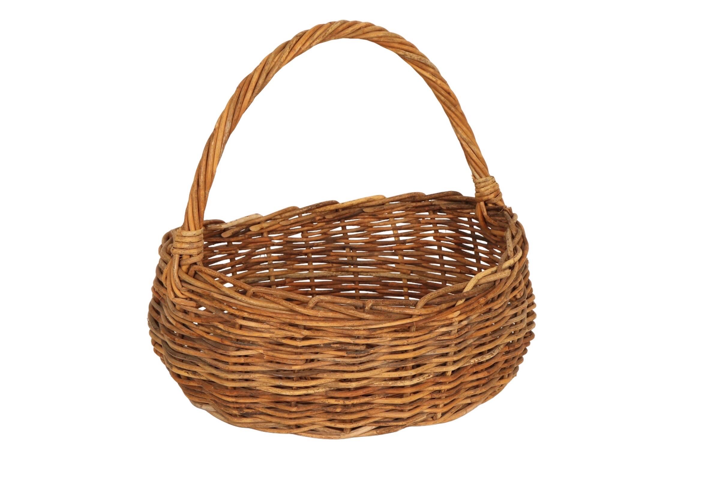 A classic French style oval shopping basket made of woven wicker. An arch like handle is made with twisted wicker woven into the sides of the basket. Decorated with a braided edge.