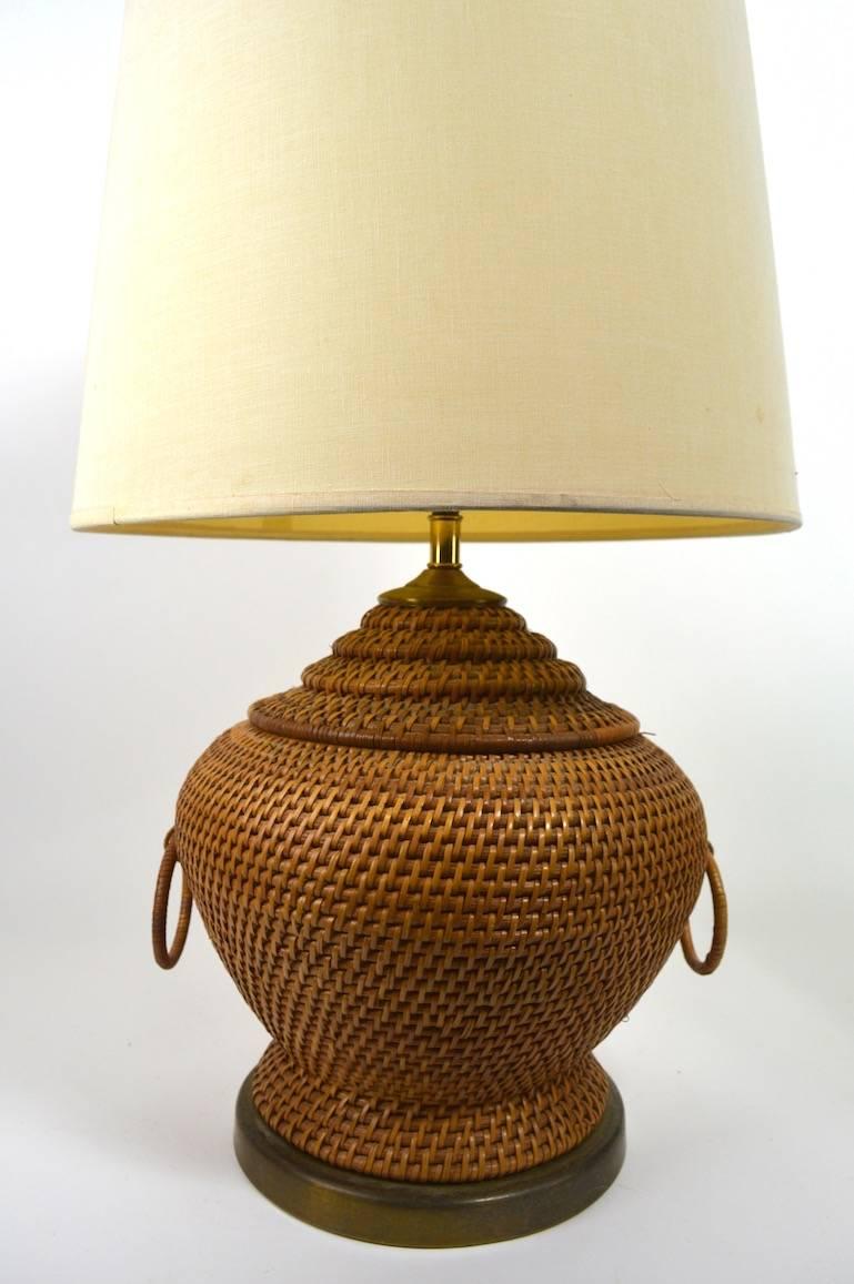 Interesting woven wicker table lamp, mounted on brass base. Charming classical form, great patina, original and working condition, shade not included.
This example is wired to accept a standard screw in incandescent bulb. Measure: Height to top of