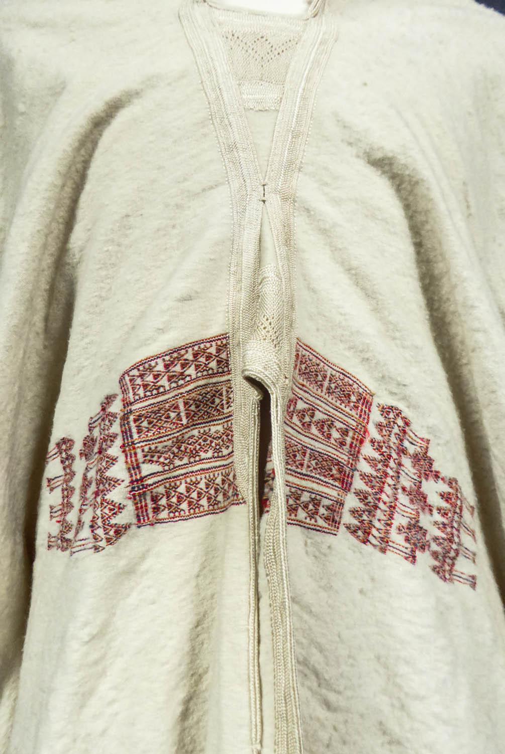 Circa 1950
Tunisia

Wide burnous cape in ivory woven wool from Tunisia dating back to the 1950s. Thick handmade downy woven wool forming a very large hooded cape. Interesting embroidery work in trimmings of cream silk threads on the front of the