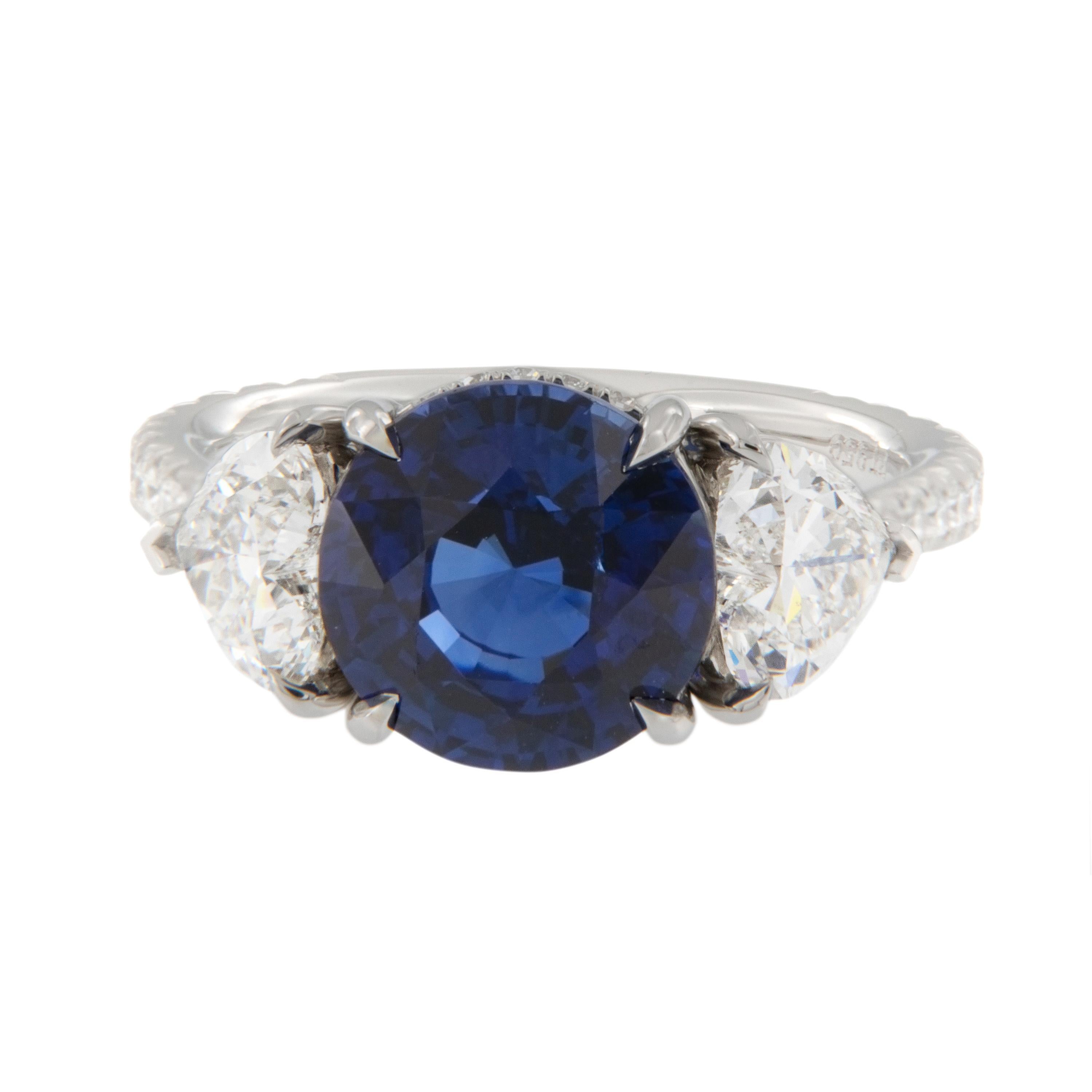 Platinum round blue sapphire (5.57Ct), 2 heart shape diamonds (1.61 Ct) and 0.40 Cttw diamond ring. Handmade in New York by William Rosenberg this once in a lifetime ring is the best of the best! The classic style ring is this beautiful blue