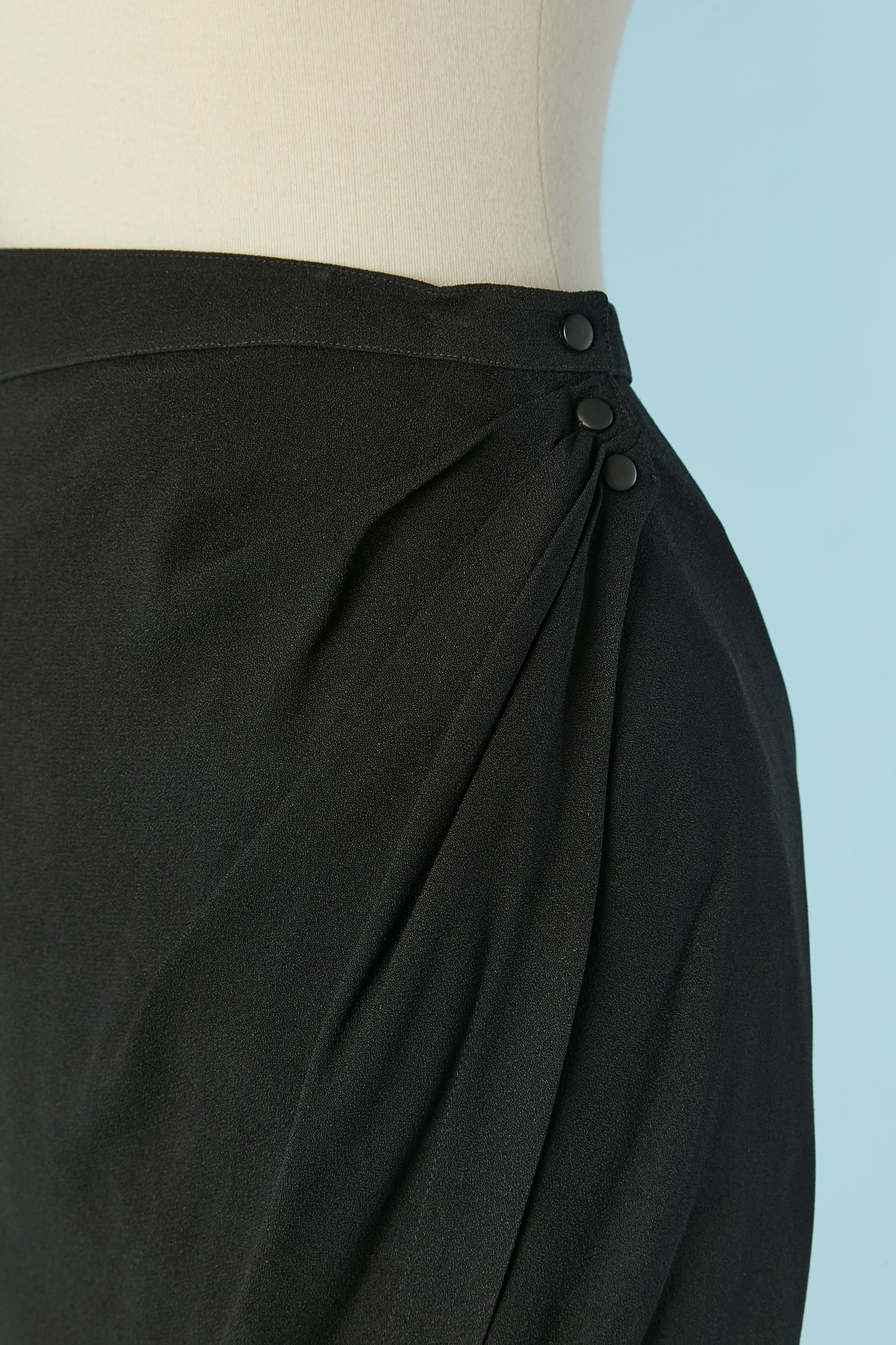 Jupe enveloppante en crêpe noir . Doublure en acétate. Fermeture à bouton-pression à la taille et fermeture auto-agrippante à l'intérieur. 
TAILLE 34 (Fr) XS 