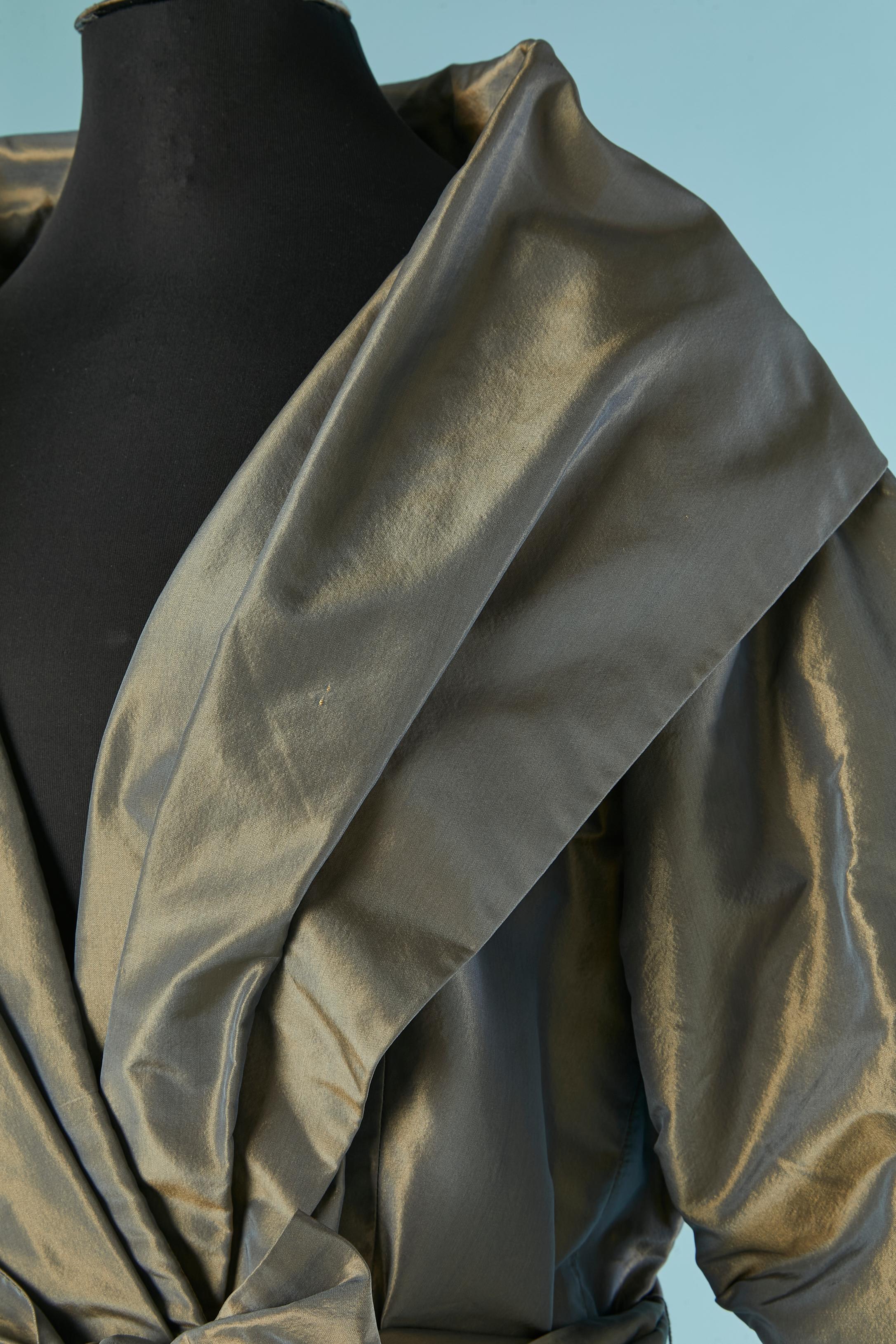 Vestido de noche envolvente de tafetán con cinturón y trabilla. Un lazo en el interior para sujetar el envoltorio y un gancho y ojo en el exterior. Bolsillo en ambos lados.
TALLA 10 (US) L 