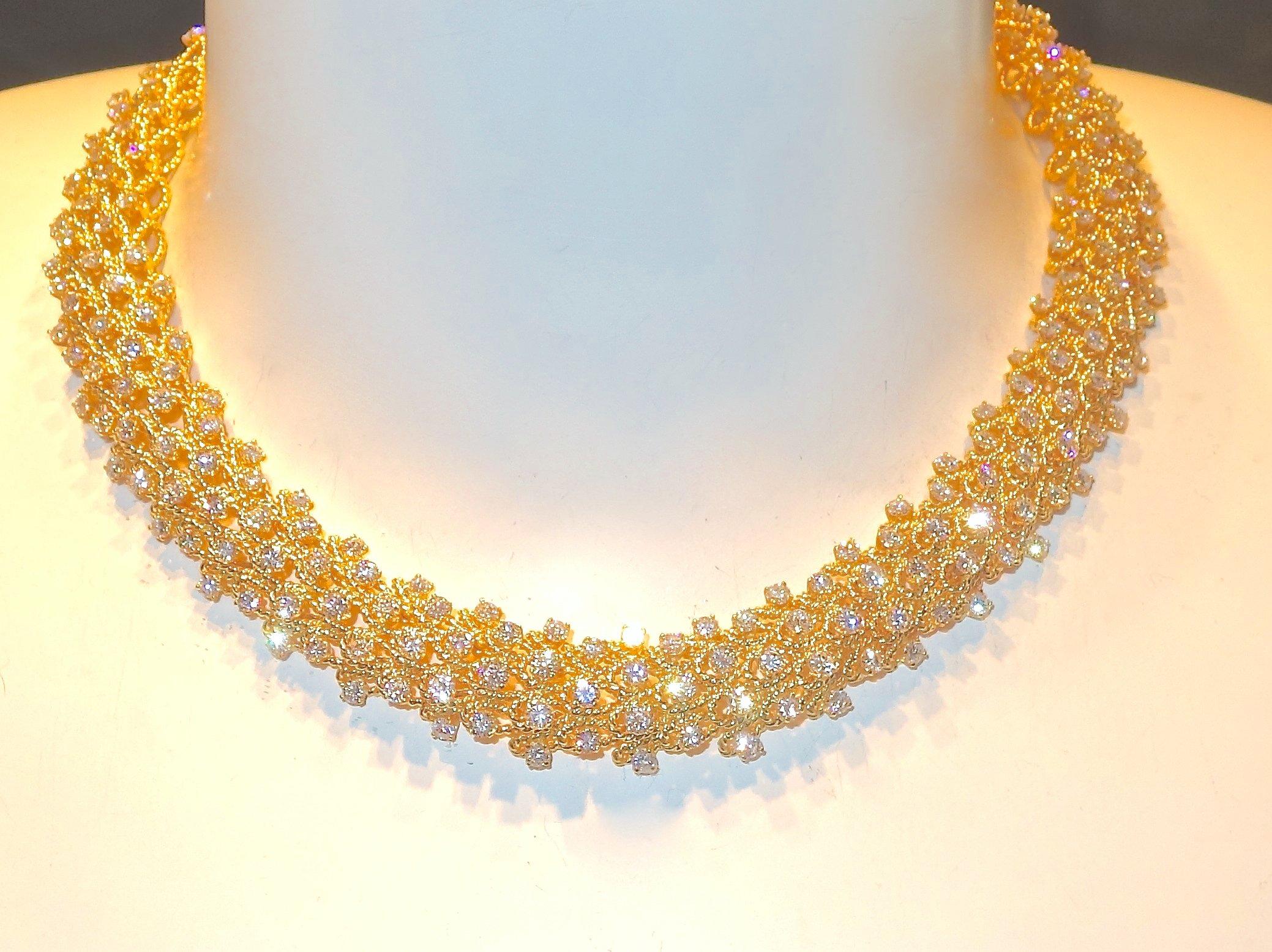 Of a wreath like design around the neck are 188 well matched and well cut  fine white round brilliant cut diamonds set in to this lovely 18K gold necklace.  The diamonds are all well matched and cut, near colorless and very slightly included (H/VS).