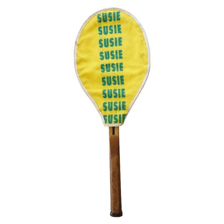 An antique wooden Wright & Ditson The Hub tennis racket and yellow and green hand-embroidered racket cover. This tennis racket is unique in that it is marked with the owner's name on a metal plaque with the year. 