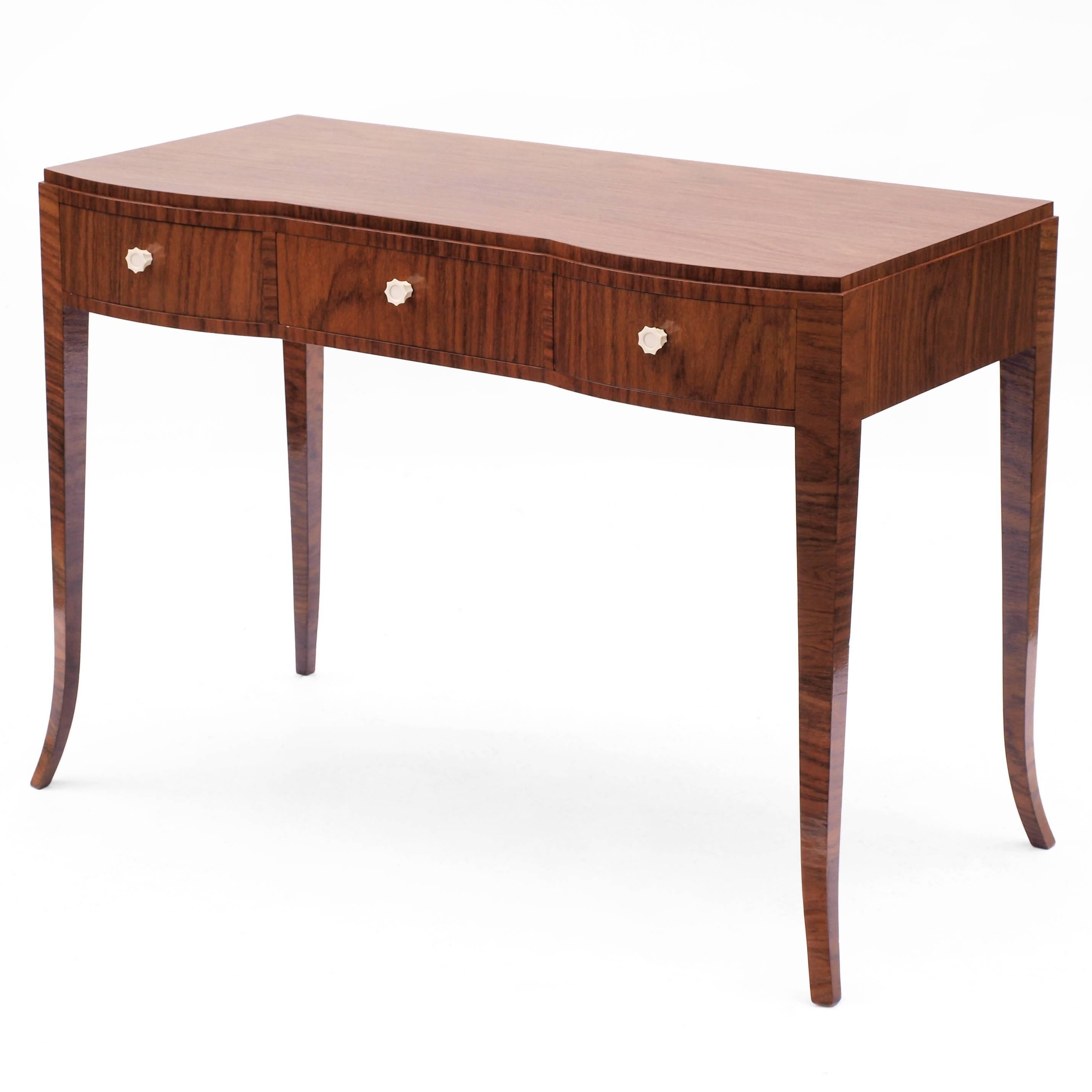 A very fine writing desk by Andre Domin & Marcel Genevriere for Maison Dominique, circa 1925.

Finished in Macassar with turned bone handles in the shape of a fluted octagon, this piece has a gently curved front with tapered and sweeping