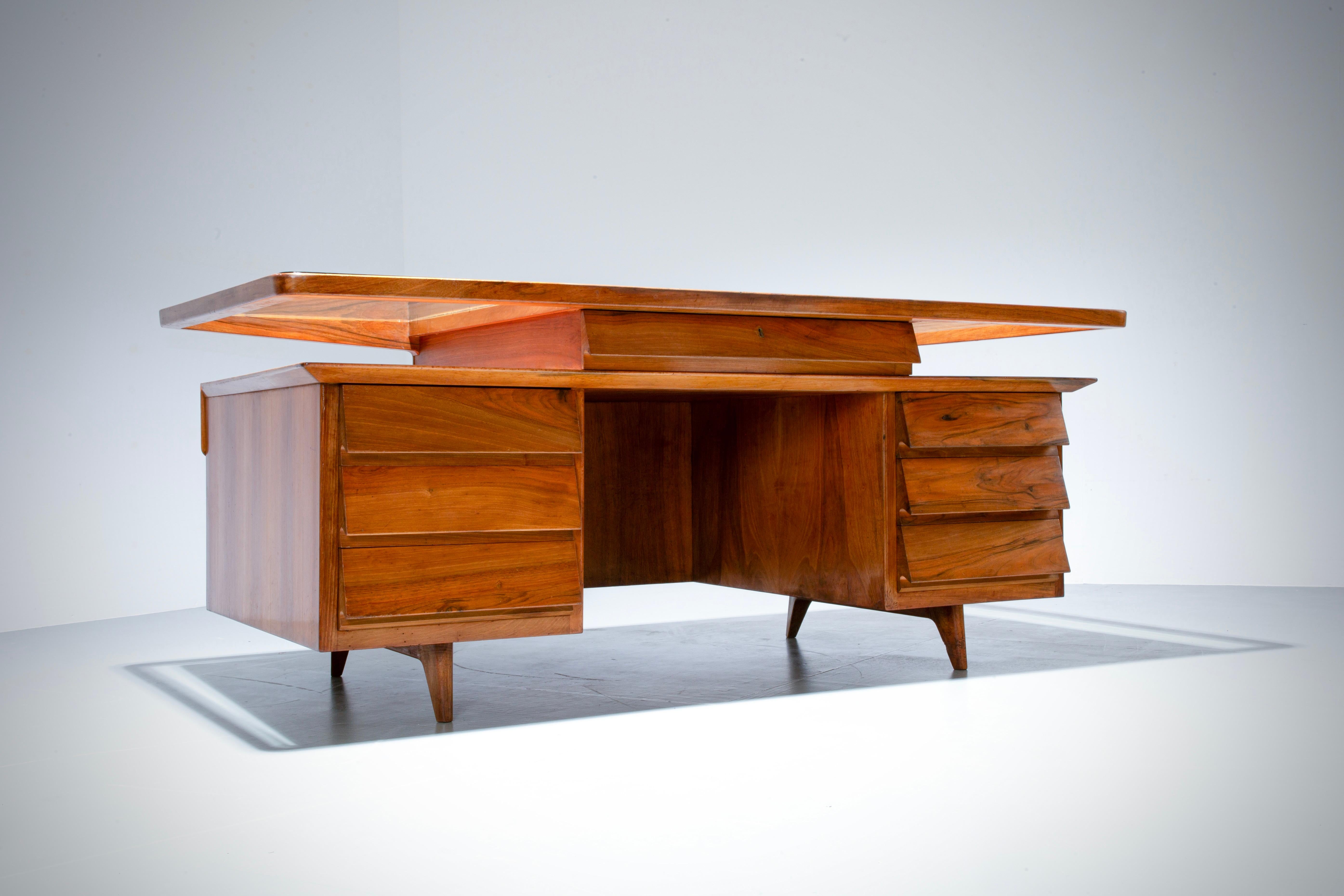 

A large symmetrical desk by Silvio Cavatorta in solid walnut with on both sides 3 drawers and in the middle a larger drawer with key and lock. For whom this lock is not safe enough: there is a hidden part behind the left lower drawer to hide