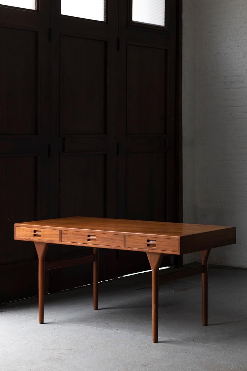 Writing desk designed by Nanna Ditzel and produced by Soren Willadsen in Denmark around 1960. This 3 drawer version has a solid teak frame and a teak veneered top. The drawers are integrated in the table top. In very good condition with minor traces