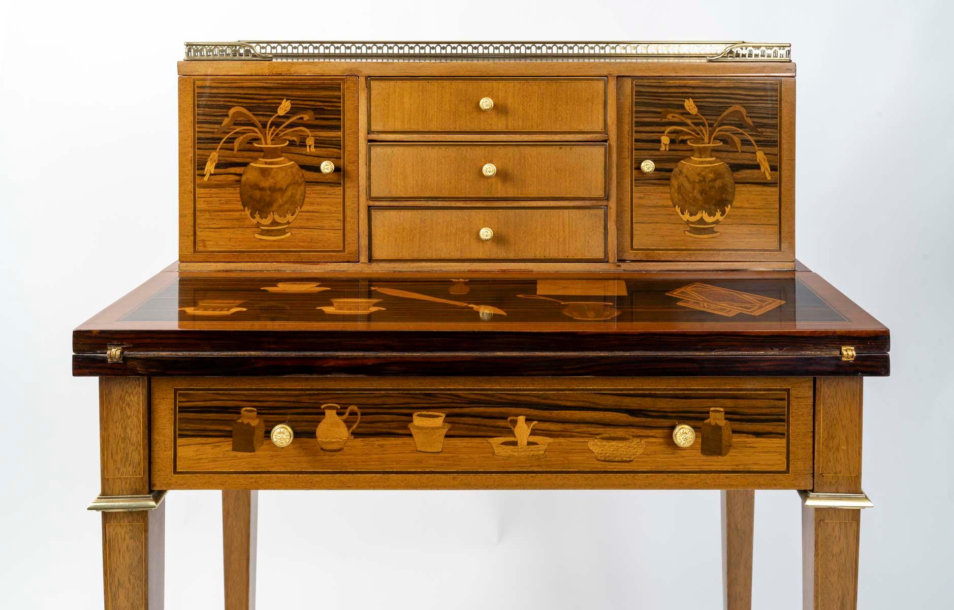 Writing desk in the Louis XVI style, early 20th century.

A Louis XVI style writing case in precious wood marquetry with writing motifs, early 20th century.
H: 103.5cm, W: 72.5cm, D: 40.5cm