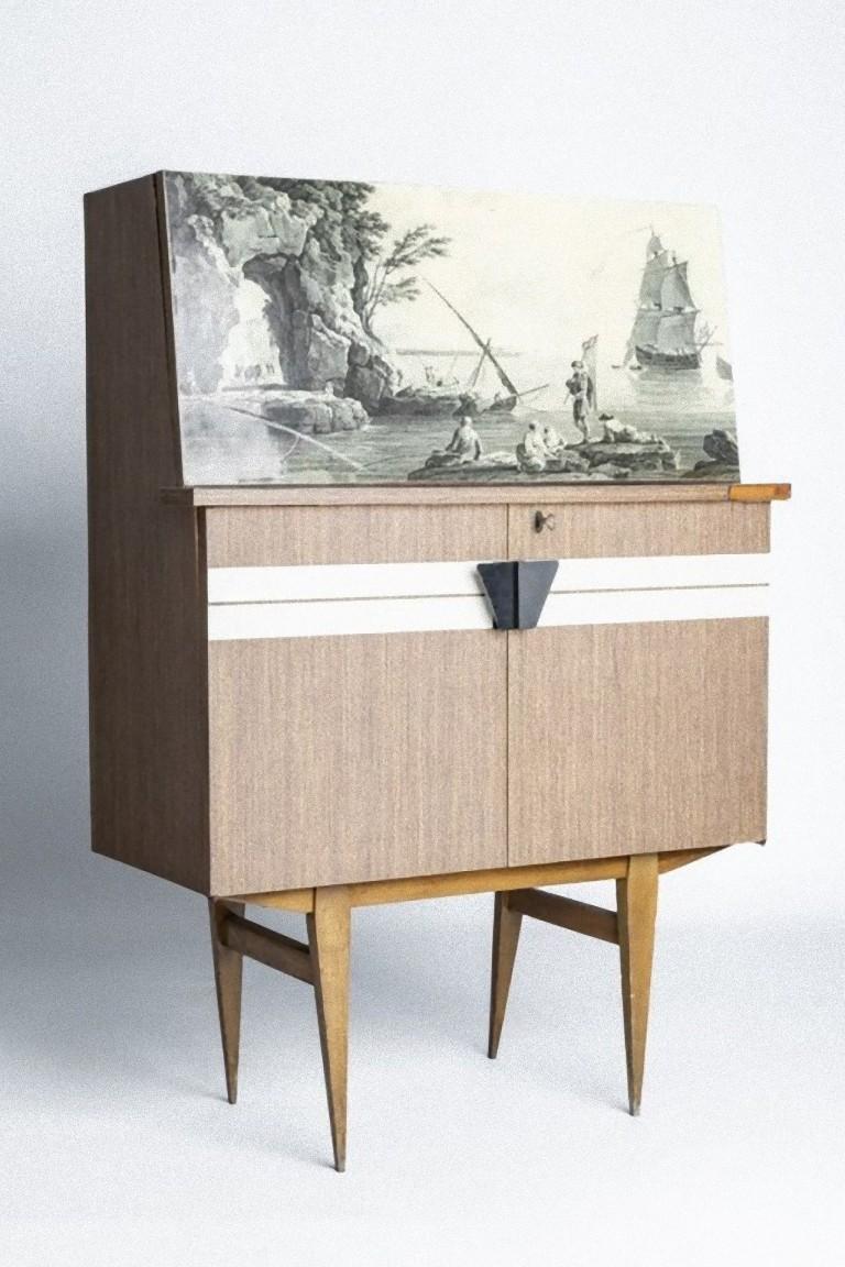 This original writing desk is a vintage design furniture realized in the 1950s by Italian manufacture.

Elegant wooden desk with marine scene depicted on the folding panel. 

Good conditions except for a loss of wood along the edge of the work