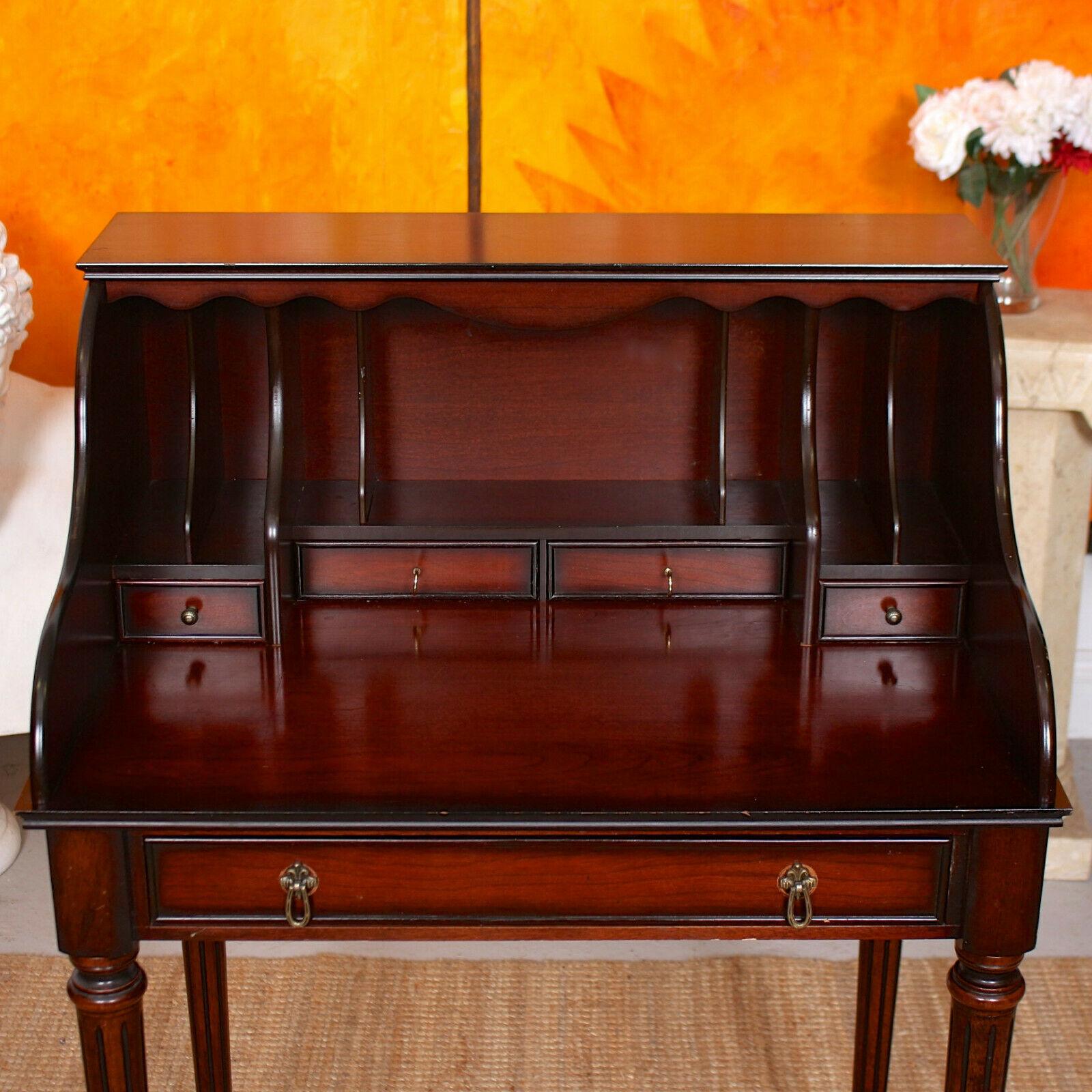 An impressive 20th century mahogany veneered writing desk.

The fitted interior comprising miniature drawers and filing compartments. Fitted a long drawer to frieze and raised on unscrewable tall slender fluted legs.