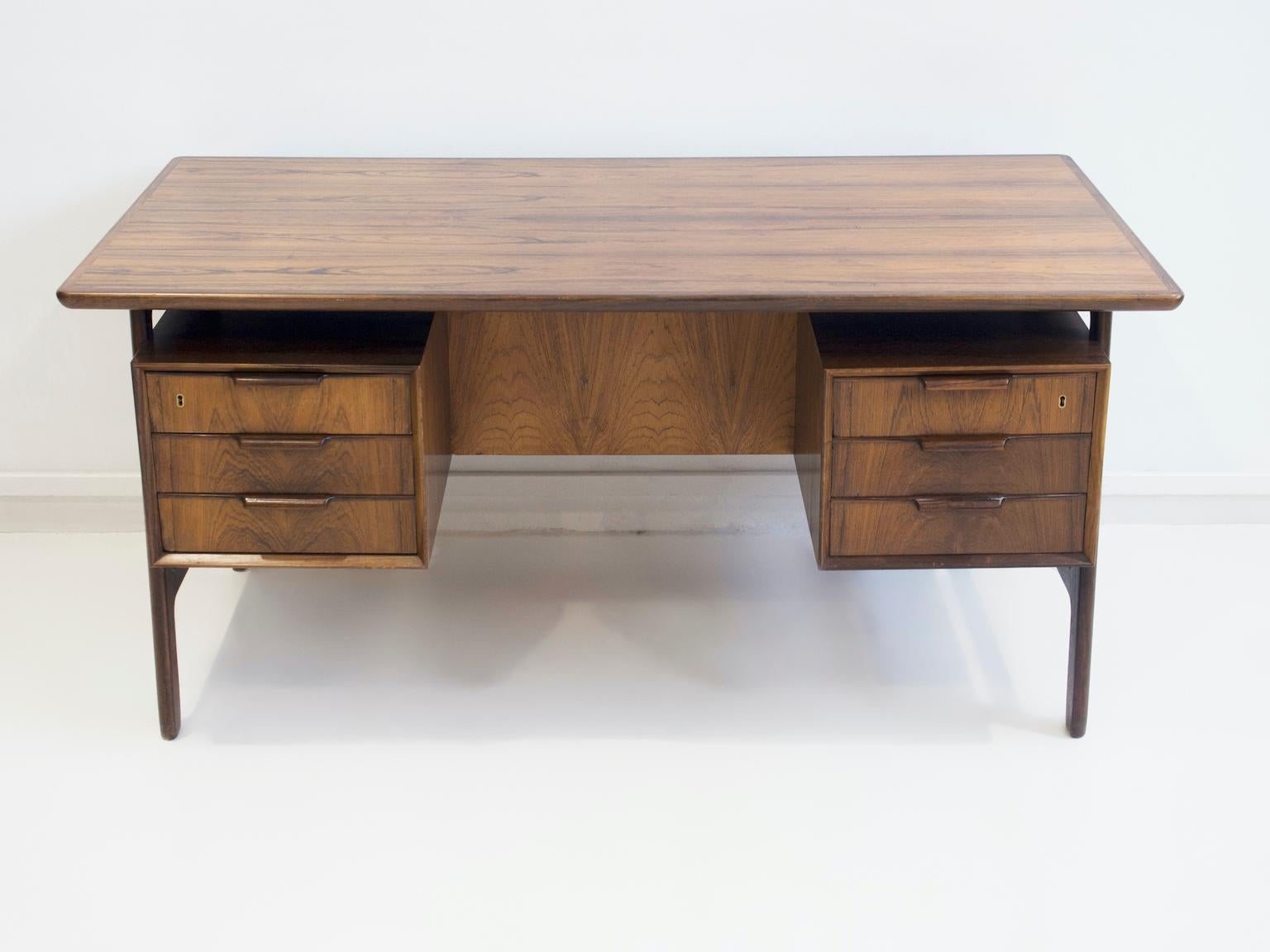 Writing desk, model 75, produced by Omann Juniors Furniture Factory. Front with six drawers, back with space for books and documents and a folding flap. Made of veneered hardwood.