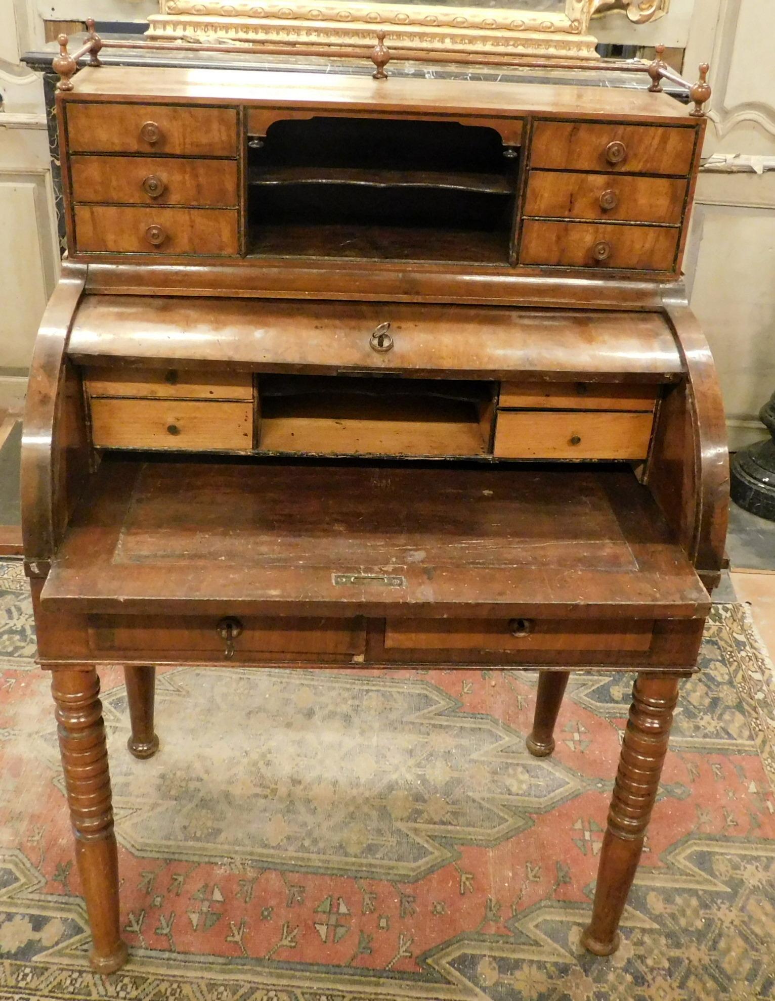 Antique piece of furniture, writing desk in walnut, hand-carved with turned legs, it was used as a bedroom due to its small size, it has twelve drawers, roller shutter and removable shelves, 19th century, built in Italy. measure cm W 80 x H 122 x D.