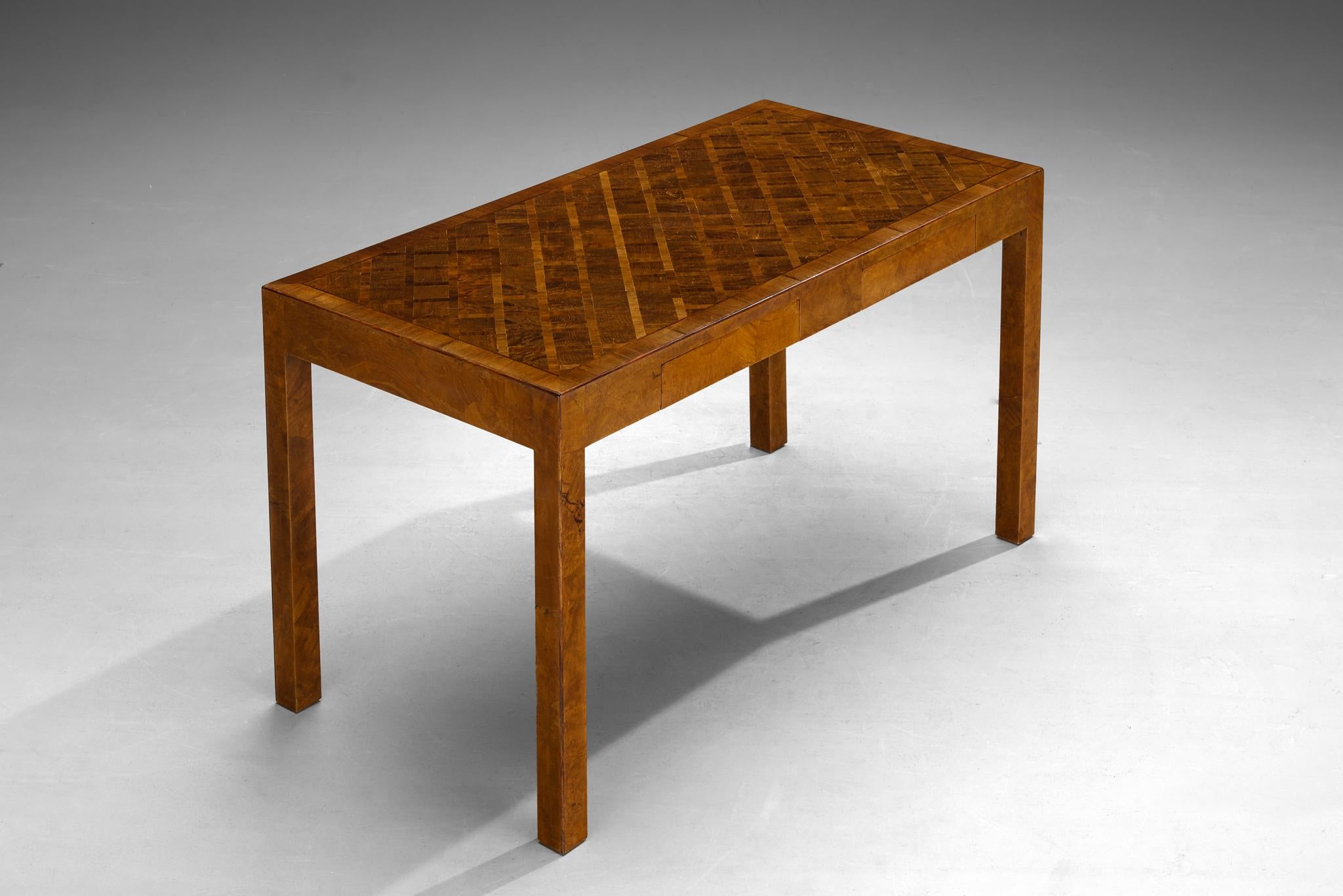 Writing table, walnut, The Netherlands, 1940s

An elegant furniture piece that attests to masterful craftsmanship. Its marquetry top, adorned with a captivating array of various wood species meticulously arranged in a geometric pattern, evokes a