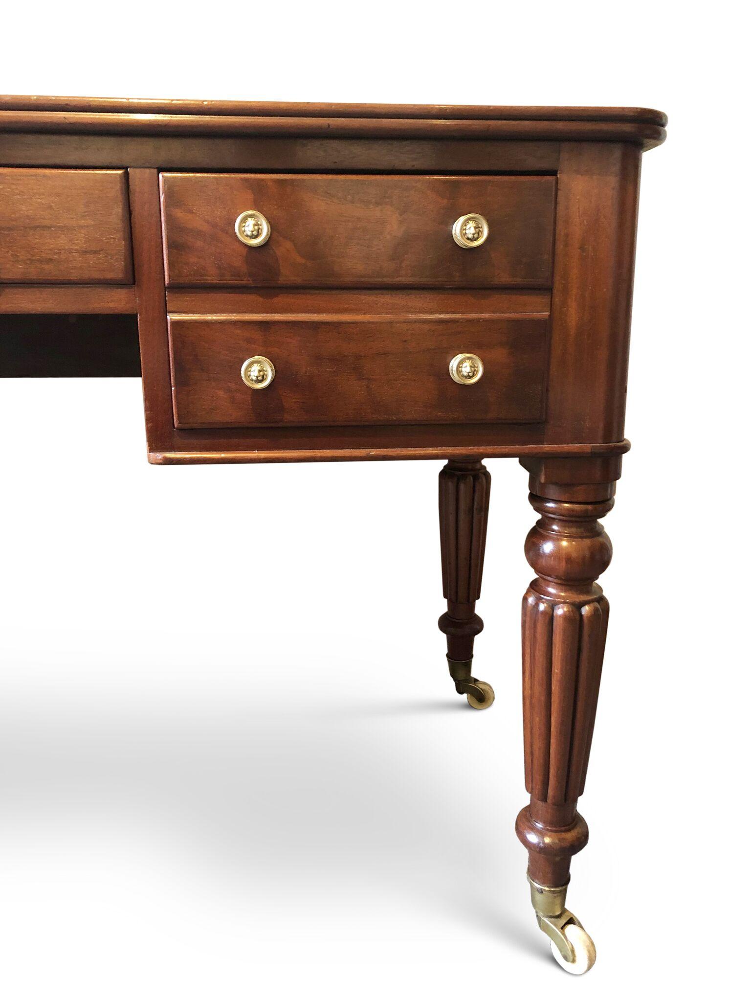 Mahogany writing table/desk of Gillows quality.
One piece nicely grained top with ribbed edge, single centre drawer flanked by two double depth drawers with dummy fronts and mahogany linings. Simple regency brass pressed knob handles, turned end