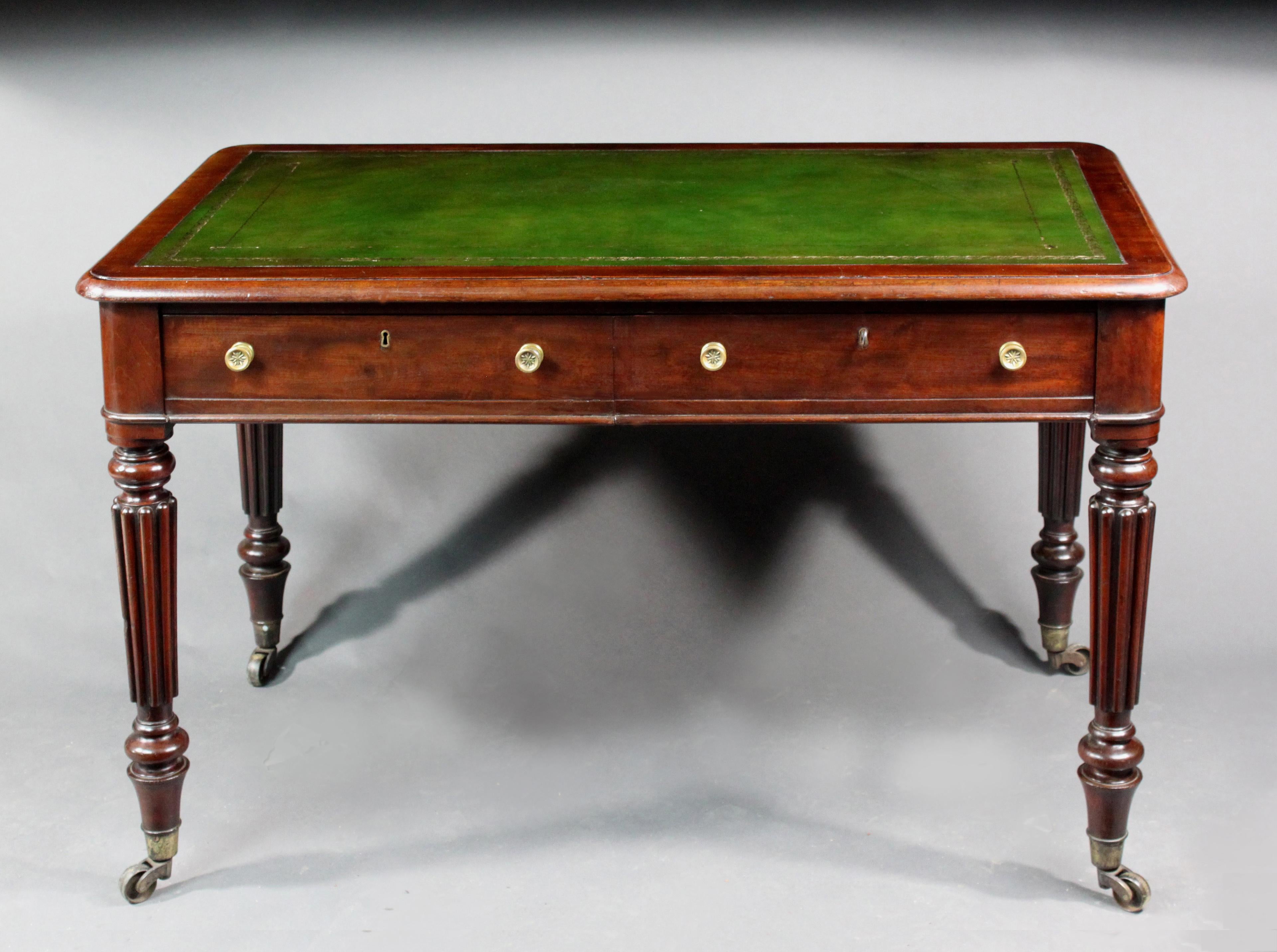 A small William IV mahogany writing on turned and reeded legs, 2 mahogany lined drawers with false drawers on the back and a fitted good quality green hide

Measures: Knee height 23.75