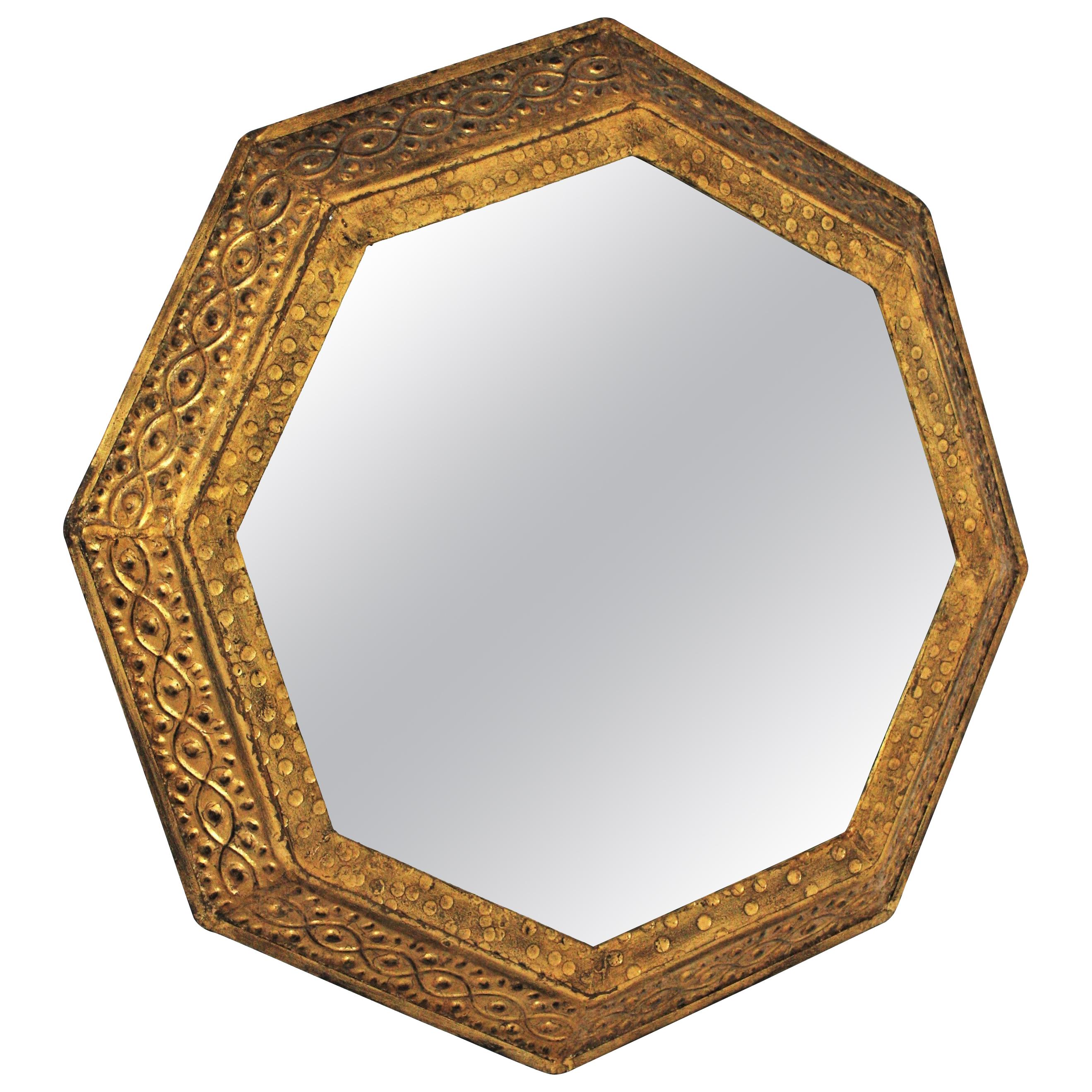 An elegant gold leaf gilt wrought iron octagonal mirror with classical patterns on the frame. Manufactured by Ferro-Art. Spain, 1950s.
This eye-catching mirror features a frame in octagon shape combinining Brutalist and Midcentury accents. It has