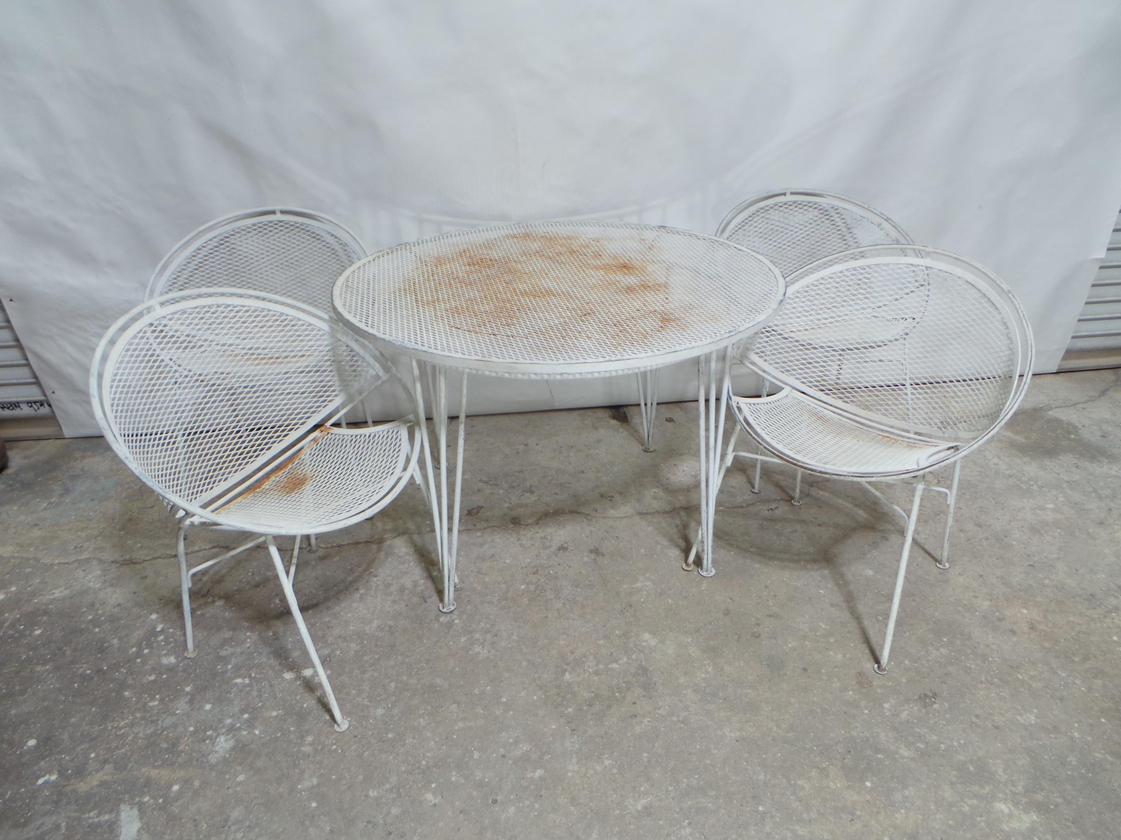 This is a Very unusual Wrought Iron 5 Piece Mid Century Garden Table + Chairs.
  they are Structurally 100% Sound but YES and new coat of paint needed.

The Table measurements are 28.5 high 42 round