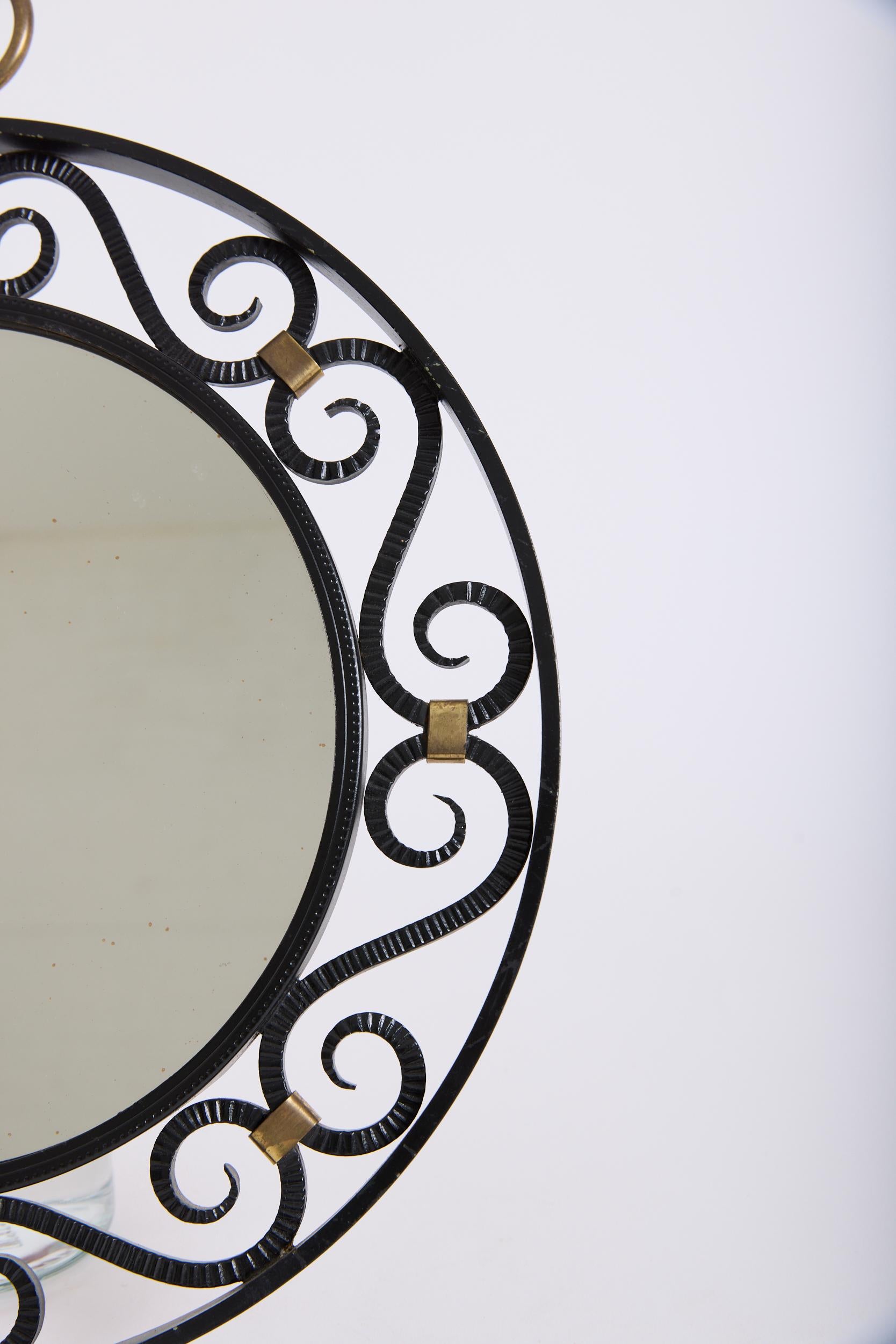 Un espejo de hierro forjado y detalles de latón
Francia, mediados del siglo XX
