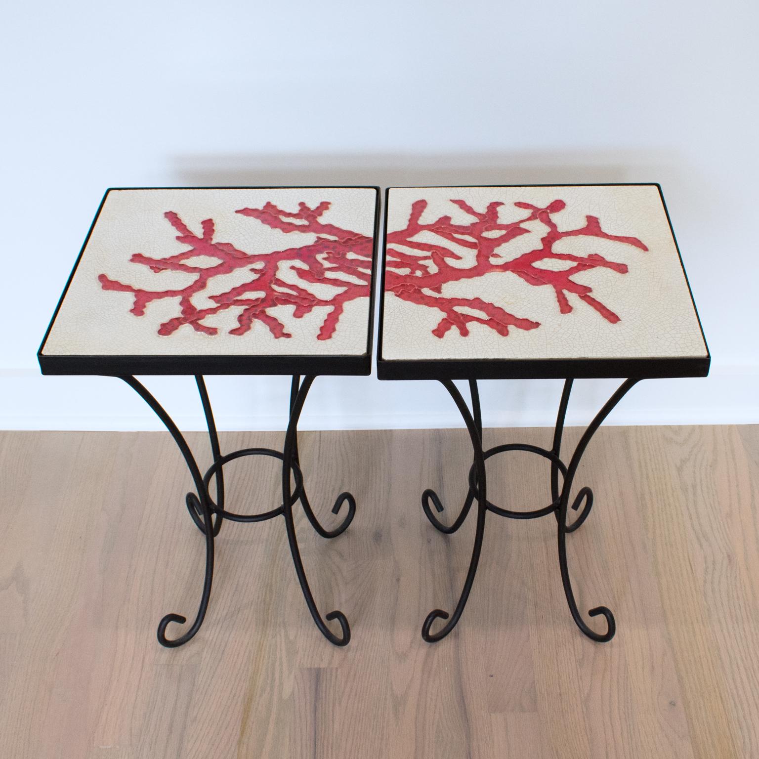 A French ceramist workshop created this elegant pair of coffee or side tables from the 1950s. The structure and legs are solid wrought iron with a matte black finish. The tables have a rounded design, with functional and robust use. The attractive