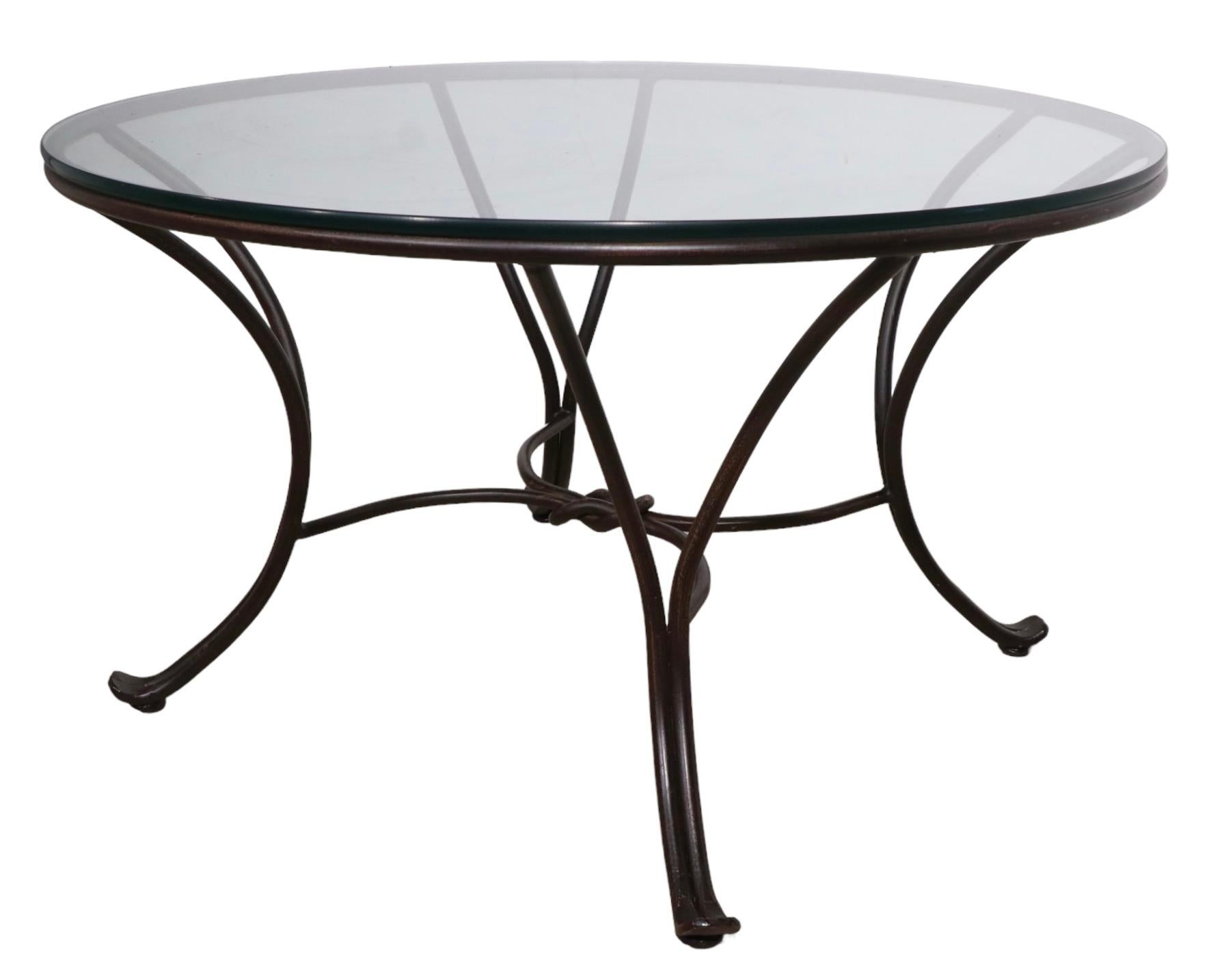 Stylish wrought iron and glass coffee table, suitable for both indoor and outdoor use. Probably circa 1970, in the manner of Woodard, Salterini etc. unsigned.