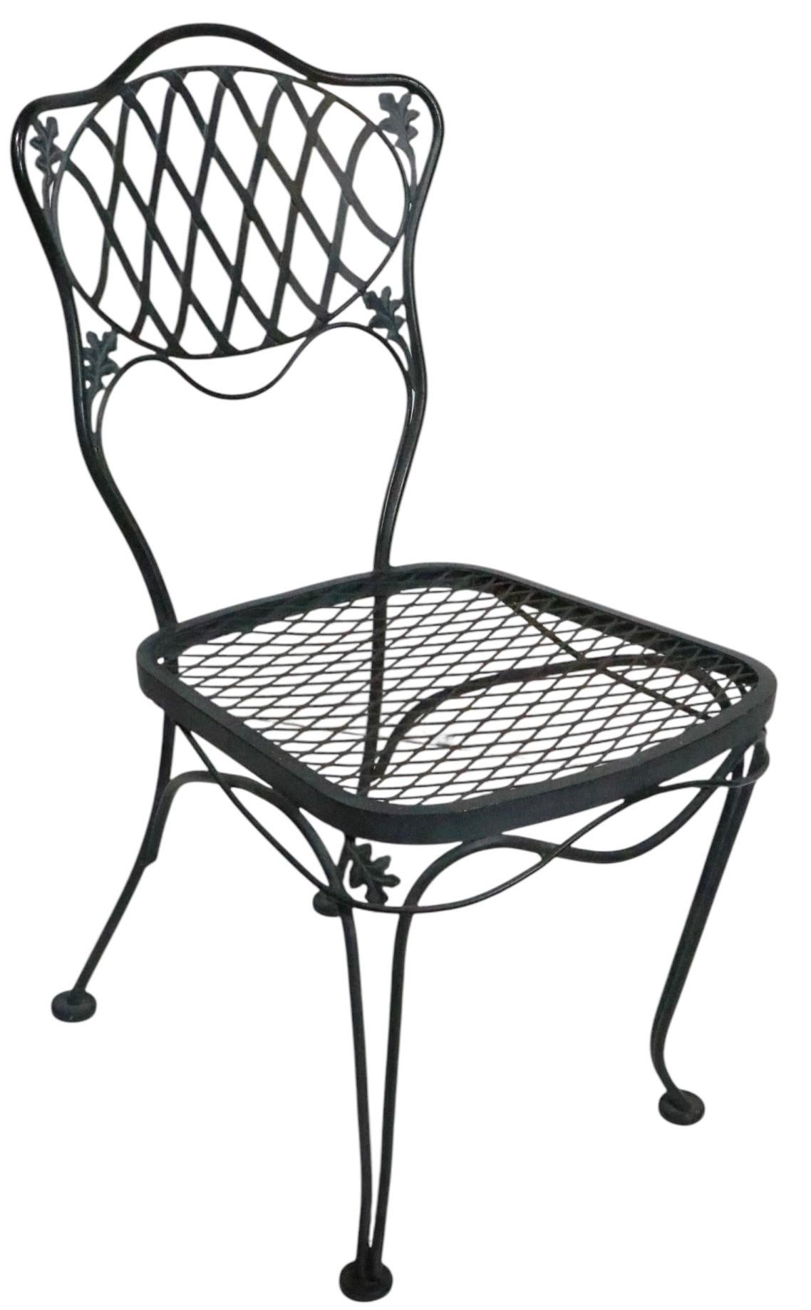 Exceptionnel ensemble de dînette vintage pour le jardin, le patio ou la piscine, par la Woodard Furniture Company, de la très recherchée série Orleans. La table présente des pieds délicatement incurvés, avec un décor de feuillage moulé, et son