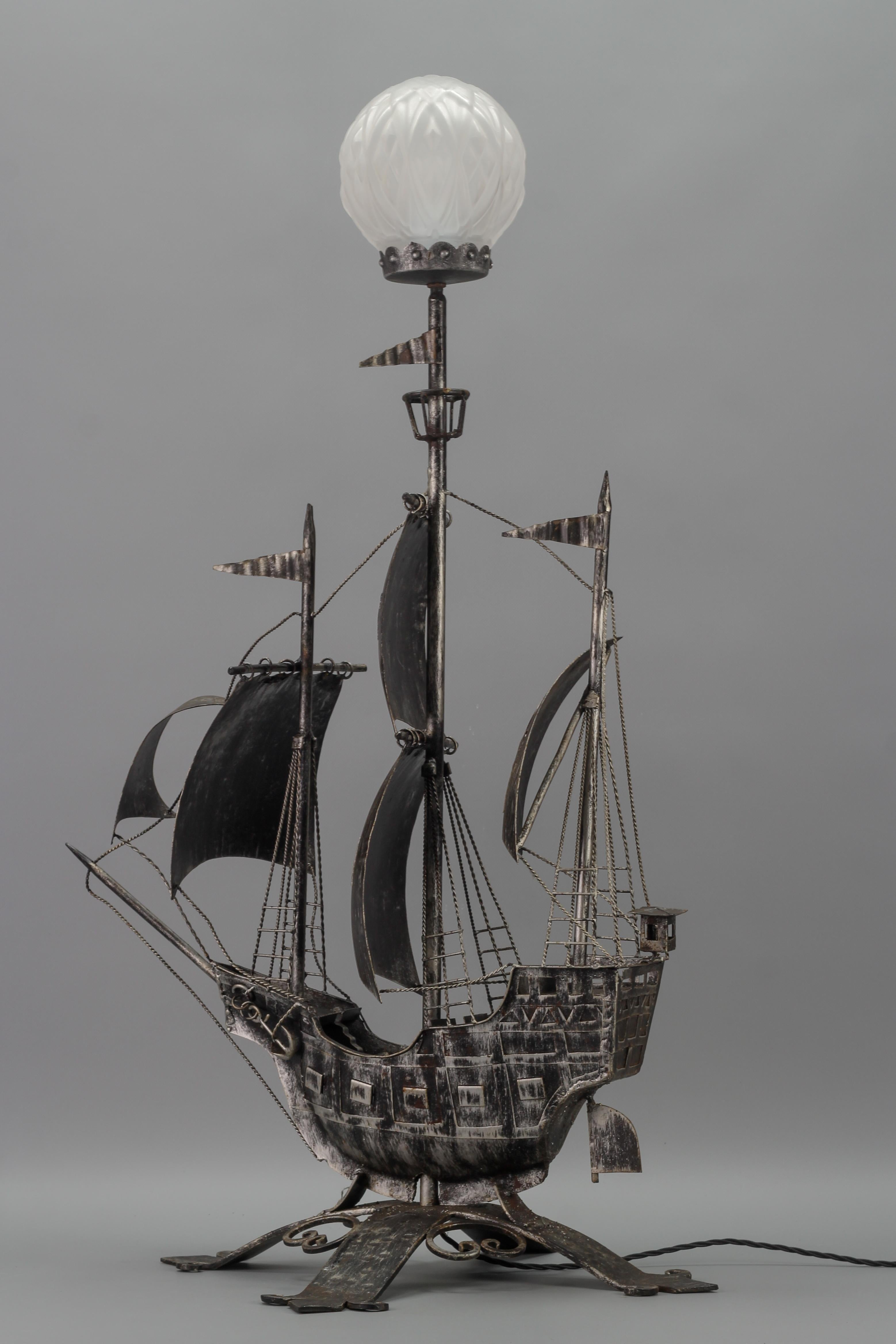 Wrought Iron and Glass Spanish Galleon Sailing Ship Shaped floor lamp, the 1950s
The impressive silver-colored iron floor lamp represents a beautiful Spanish galleon with three masts and sailing ship details such as sails, ropes, anchor, and flags.