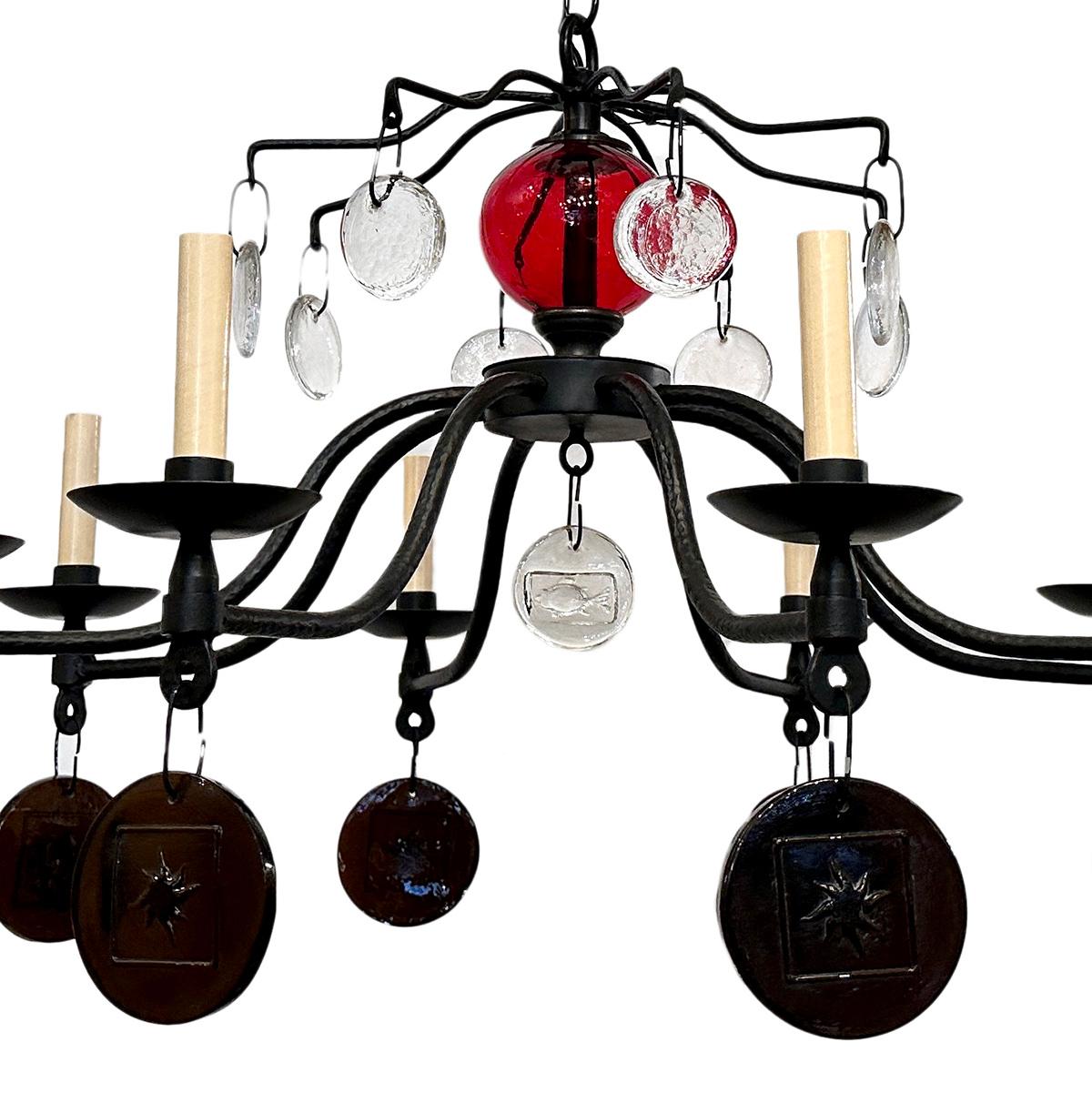 A circa 1970 wrought iron chandelier with 8 lights. Glass insets and pendants.

Measurements:
Drop: 32