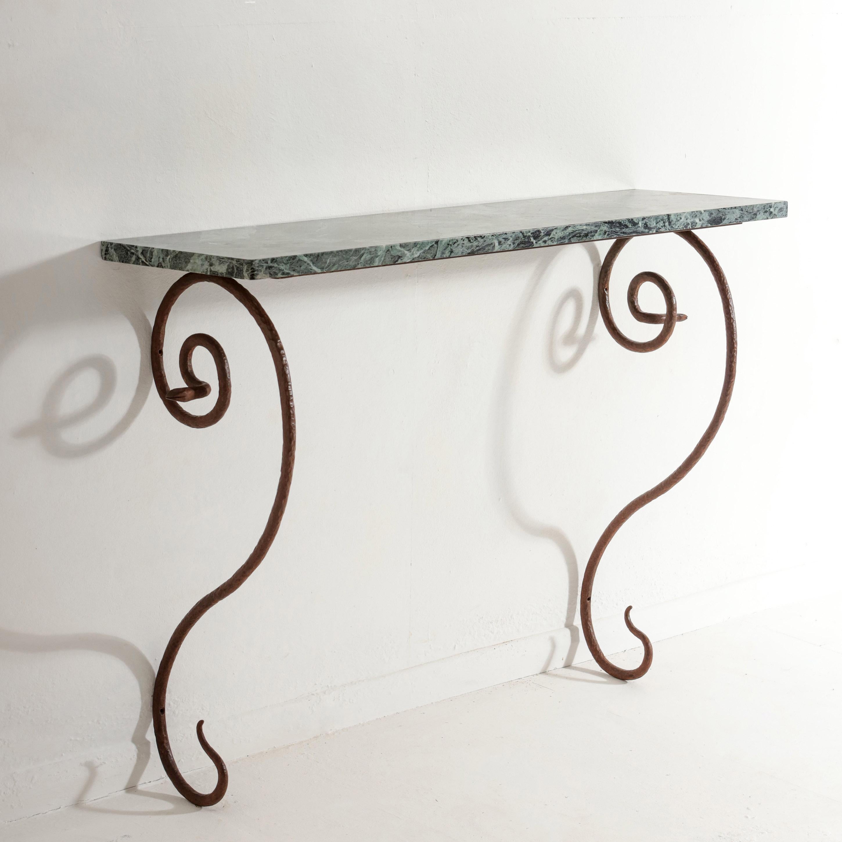 Wrought Iron and Marble Console In the Manner of Paul Poiret.

Patinated wrought iron base featuring of a pair of serpents, with an impressive marble top. 

Wall Mounted by 6 fixings, hammered patination to enhance the 